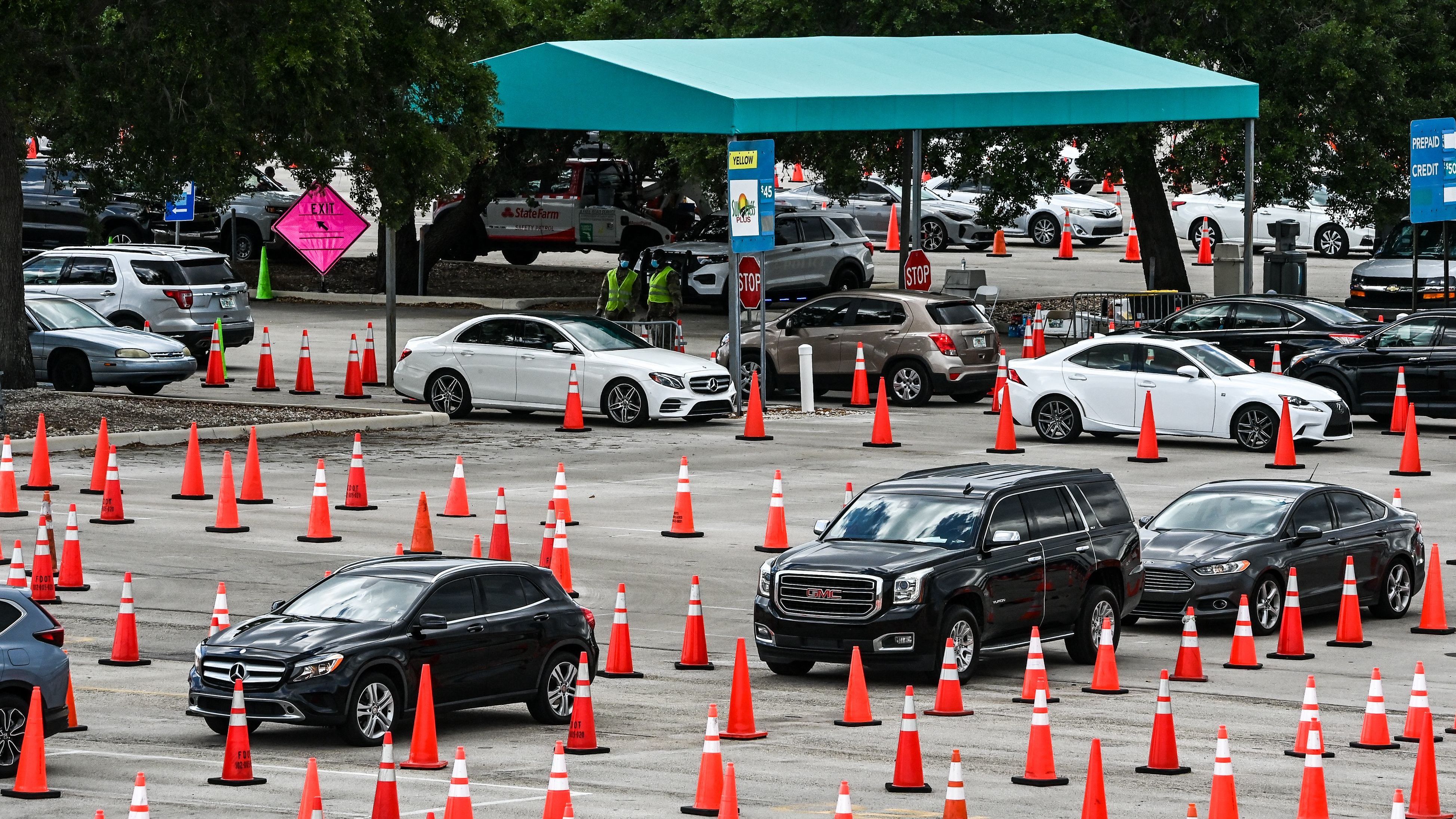 People wait in their vehicles to get vaccinated last week at a drive-through site at Hard Rock Stadium in Miami Gardens, Fla. President Biden announced an April 19 deadline for all states to open eligibility to individuals ages 18 and up.