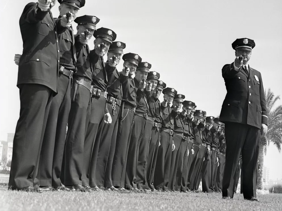 A line of policeman take aim. (Bettmann/Bettmann Archive)