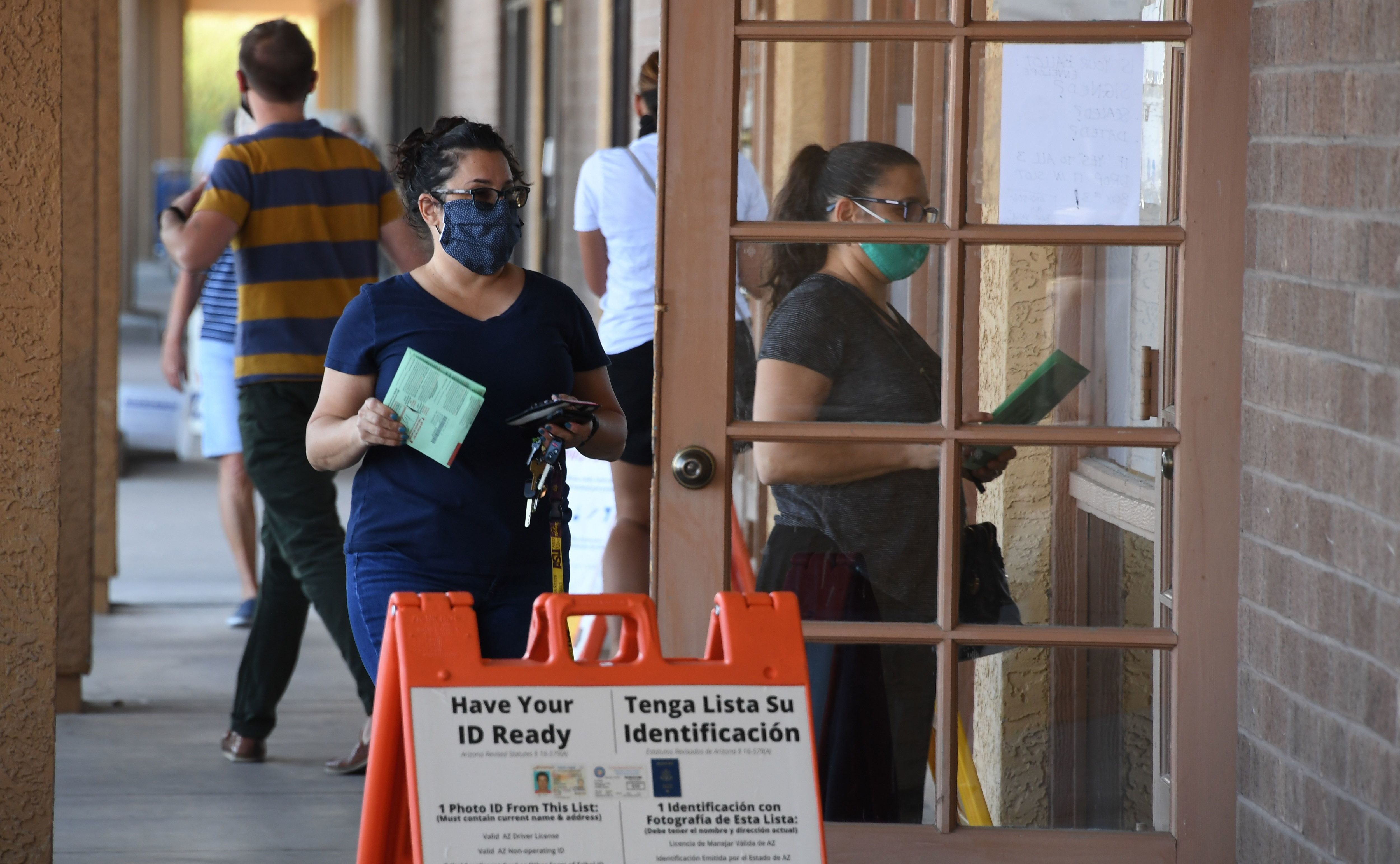 People arrive to drop off mail-in ballots or vote in person at an early voting location in Phoenix on Oct. 16, 2020. Republicans in Arizona are weighing measures to make the state's voting rules more restrictive. (AFP via Getty Images)