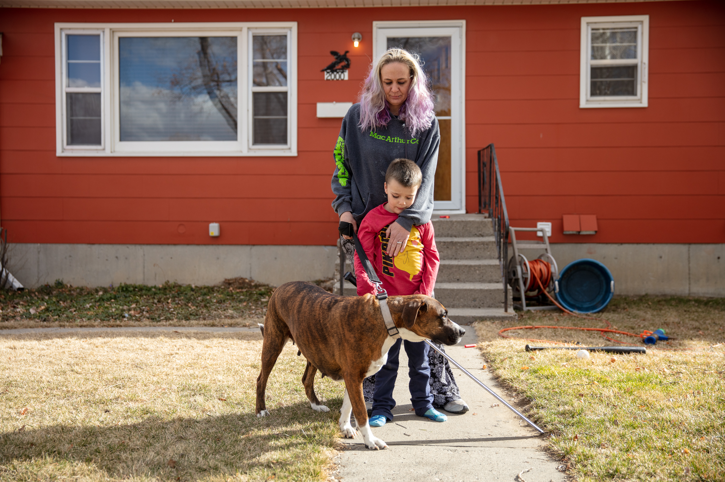 Barbara Gaught stands outside the home she's now renting in Billings, Mont., with her 5-year-old son, Blazen, and their dog, Arie. Gaught and her family were evicted from the mobile home they had owned outright and lived in for 16 years because they fell behind on 'lot rent' for the little plot of land under the mobile home. (Louise Johns for NPR)