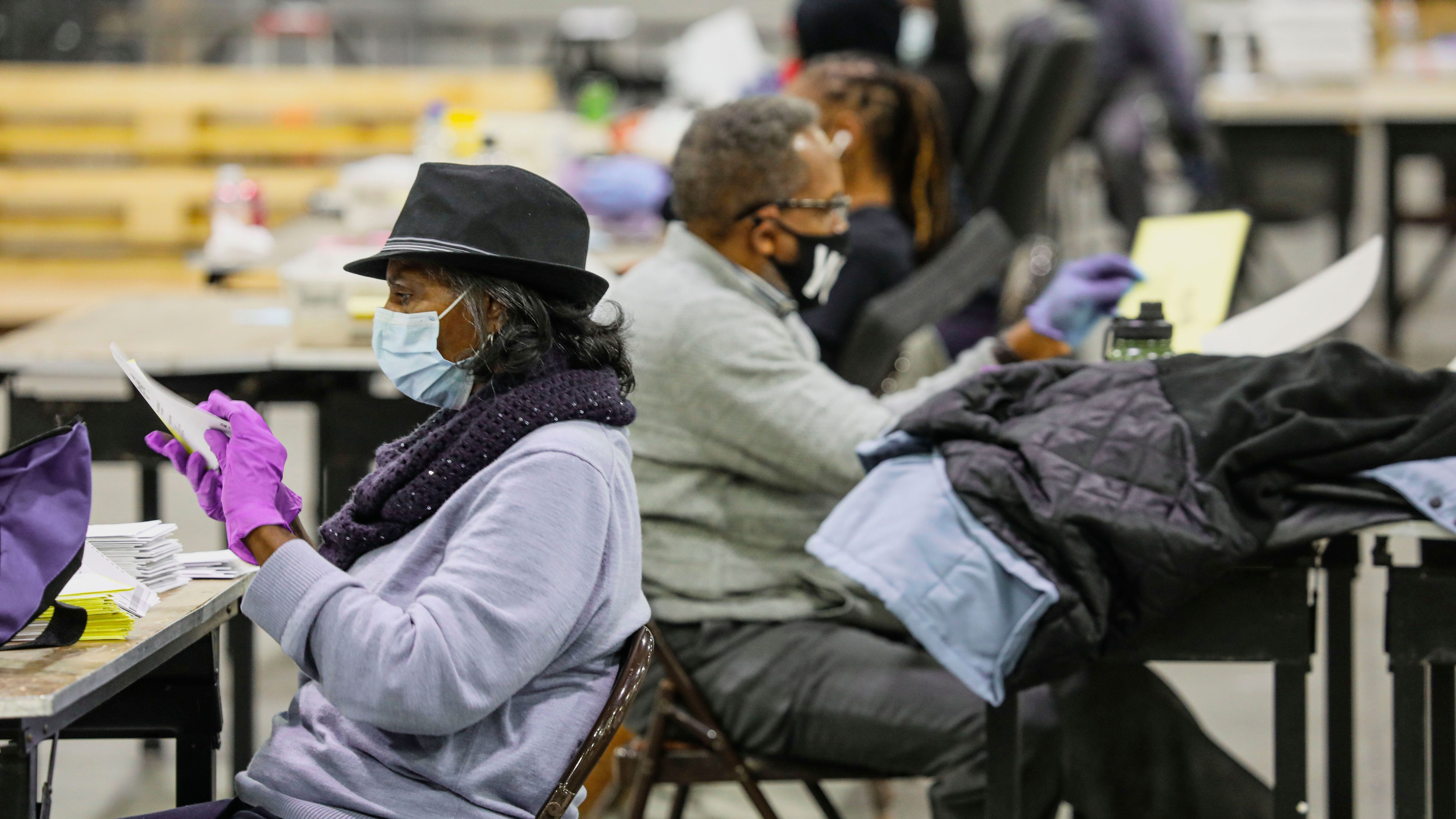 Atlanta election workers scan ballots and check for discrepancies earlier this year for Georgia U.S. Senate races. The state's controversial new voting law contains many changes for election officials. (AFP via Getty Images)