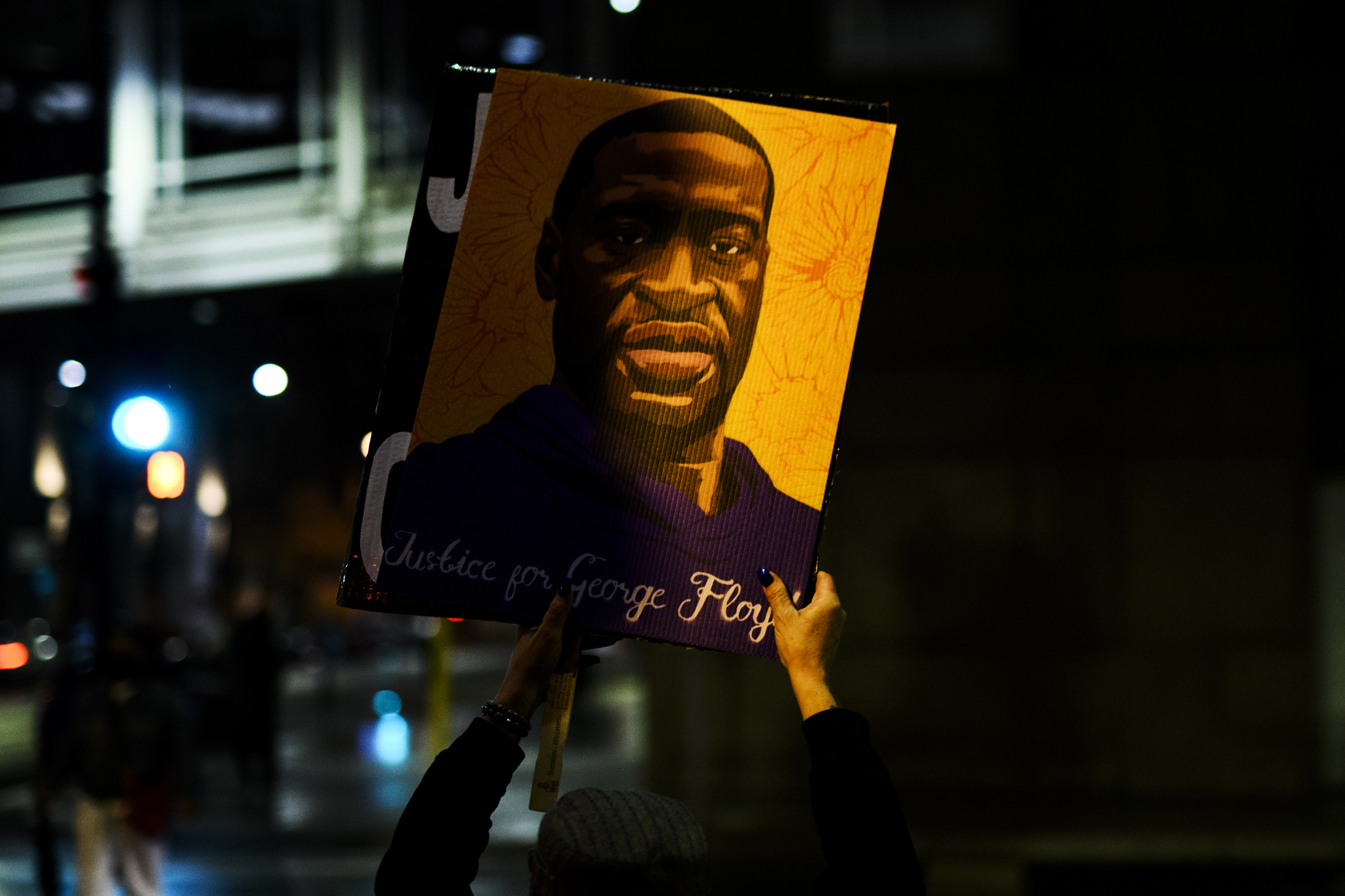A person holds up a portrait of George Floyd as people gather outside the Hennepin County Government Center on April 9 in Minneapolis (Getty Images)