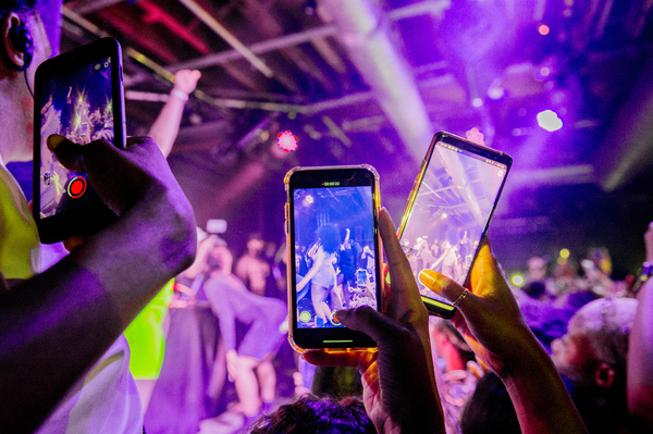 You can do a lot of things with minimal risk after being vaccinated. Although our public health expert says that maybe it's not quite time for a rave or other tightly packed events. Above: Fans take photographs of Megan Thee Stallion at a London show in 2019.