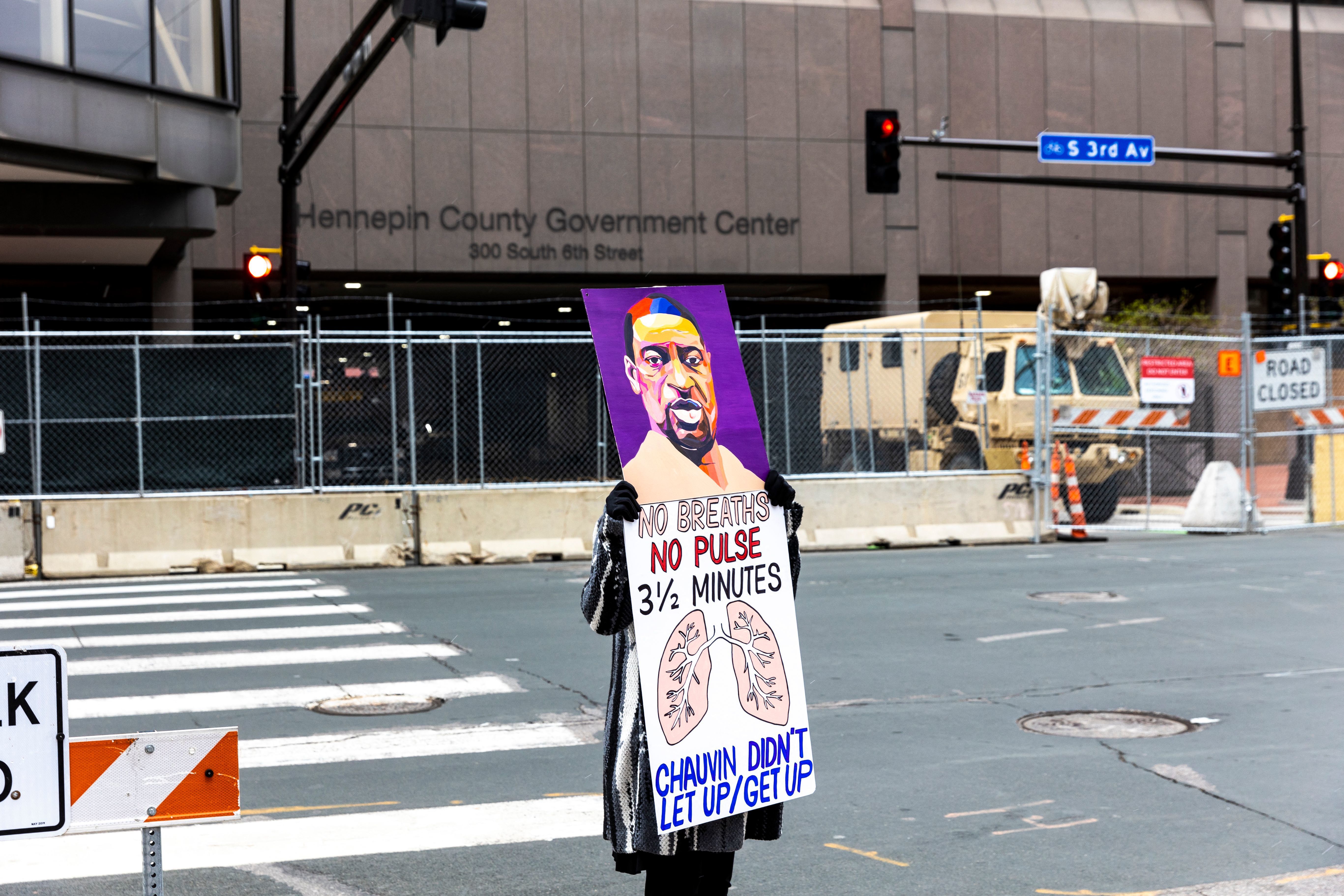 A lone protester stands outside the Hennepin County Courthouse on Monday as lawyers presented closing arguments in the murder trial of Derek Chauvin. The jury is now deliberating. (AFP via Getty Images)