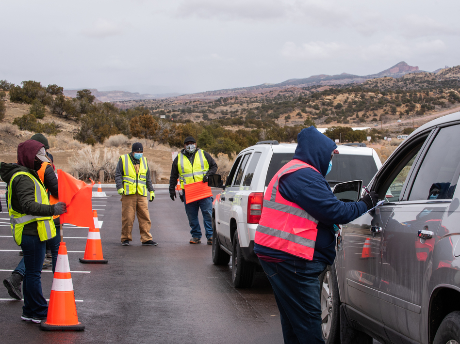 Workers greet arrivals at a drive-in vaccination site at University of New Mexico's Gallup campus in Gallup, N.M., on March 23. The Navajo Nation has vaccinated more than half of its adult population, outpacing the U.S. national rate. (Cate Dingley/Bloomberg via Getty Images)