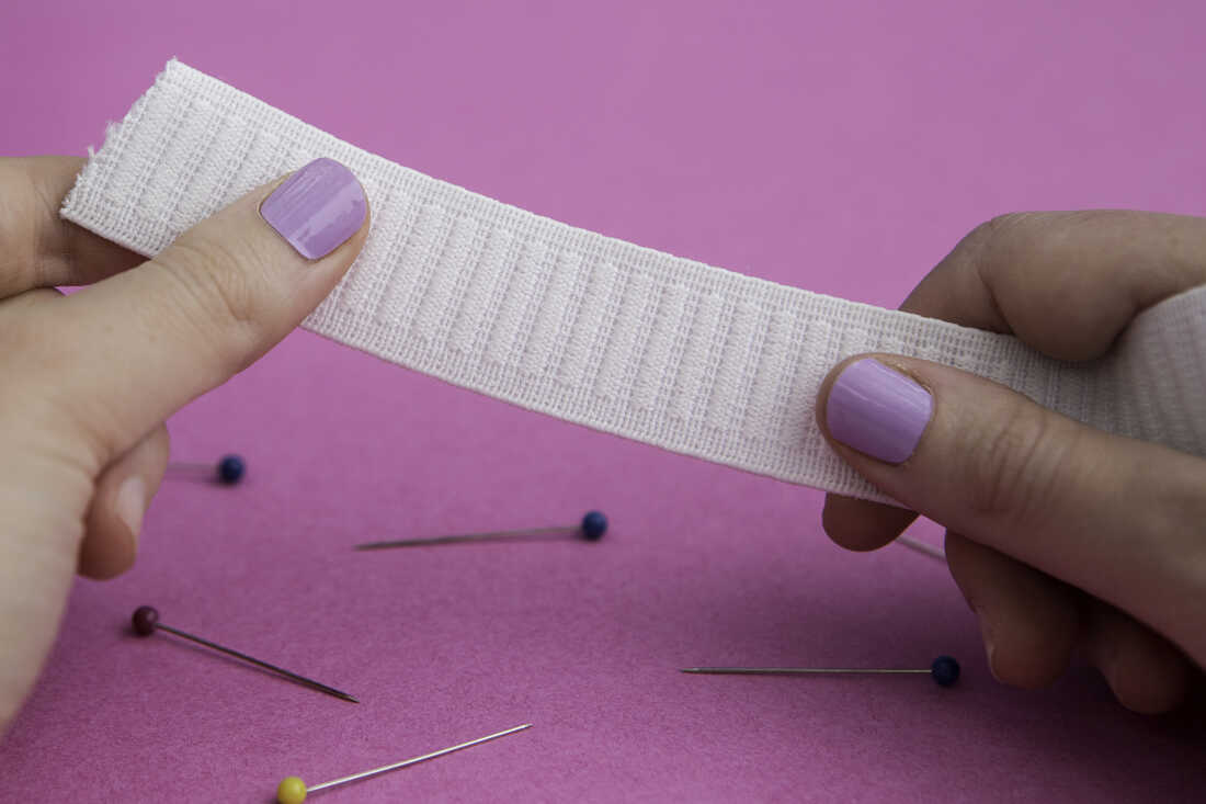 An employee of 'mey bodywear' sews together pieces of fabric for