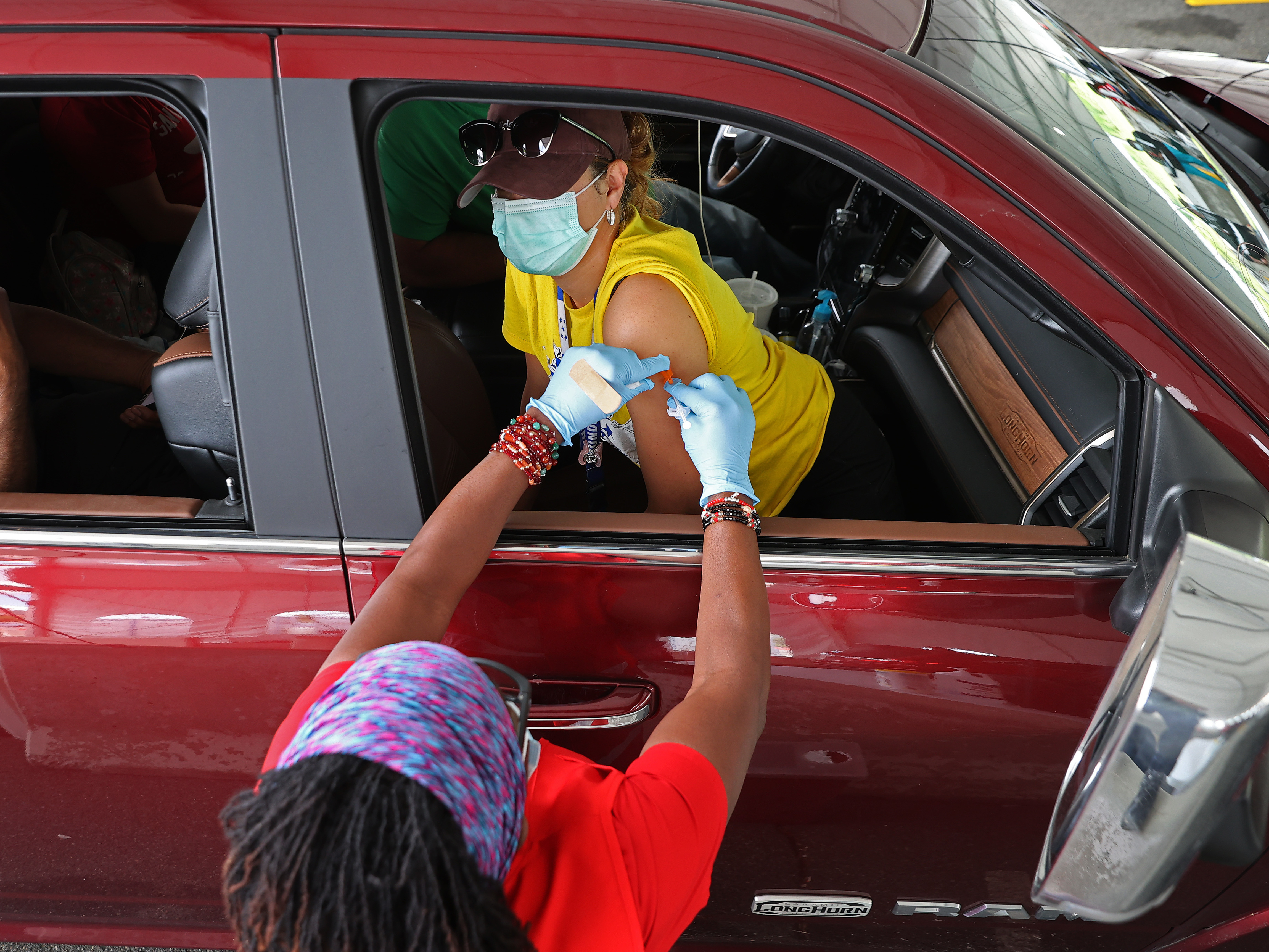 People who need help getting to a vaccination site will be able to get free or discounted rides through Uber and Lyft, the White House says. Here, a woman receives her first dose of the Pfizer vaccine at a mass vaccination site in Aberdeen, Md., after getting a ride to the site from her landlord. (Getty Images)