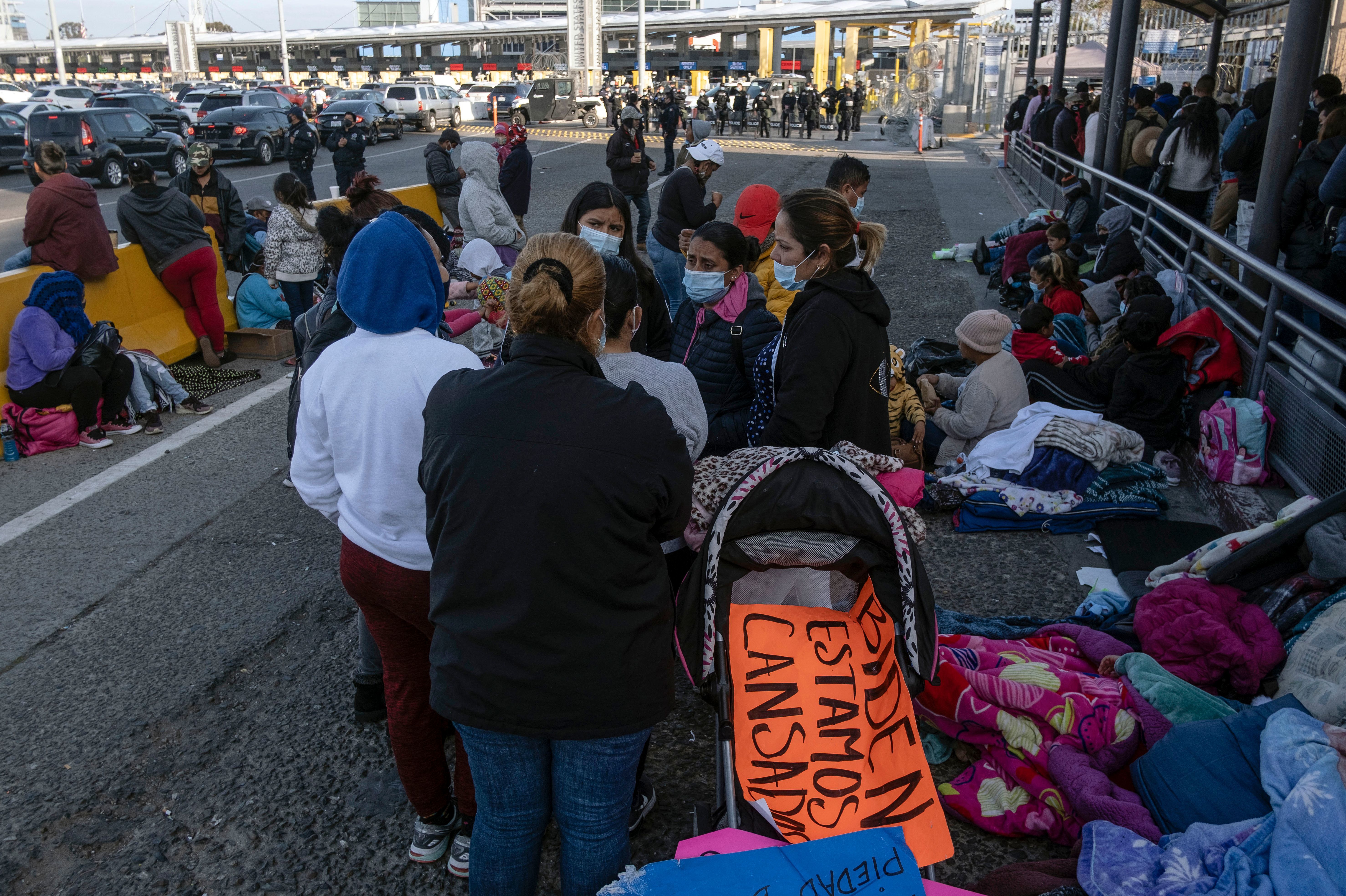 Migrants and asylum seekers are seen after spending the night in one of the car lanes off the San Ysidro Crossing Port on the Mexican side of the U.S.-Mexico border in Tijuana on April 24, 2021. A group of migrants asked U.S. migration authorities to allow them to start their migration process and decided to stay at the crossing port to pressure for a solution to their situation. (AFP via Getty Images)