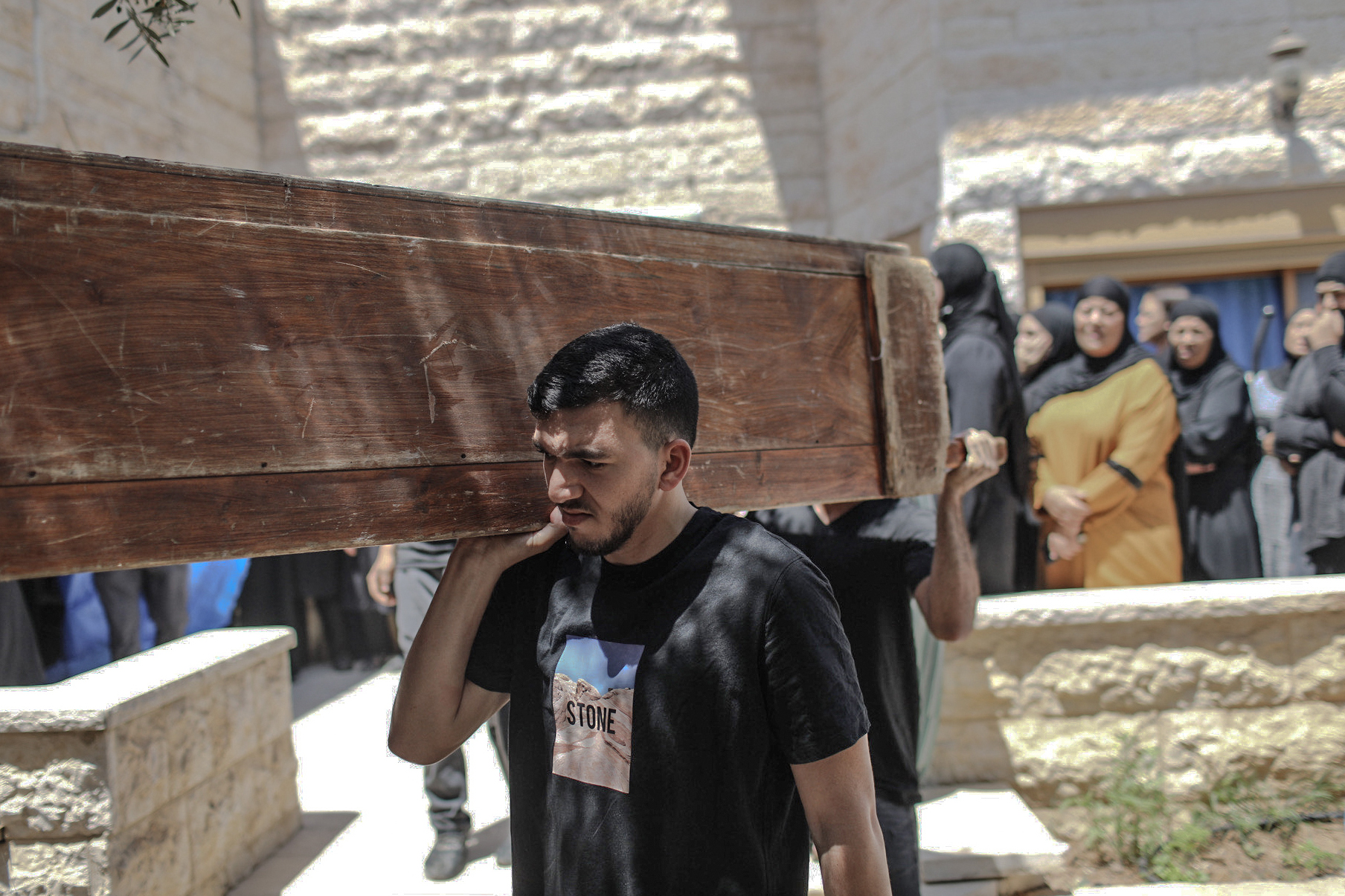 Mourners carry the coffin of Khalil Awad, 52, at the funeral for him and his 16-year-old daughter, Nadin Awad. The two Palestinian citizens of Israel were killed early Wednesday when a rocket fired from the Gaza Strip hit their home in Dahmash, a village near the city of Lod, Israel. (picture alliance via Getty Images)