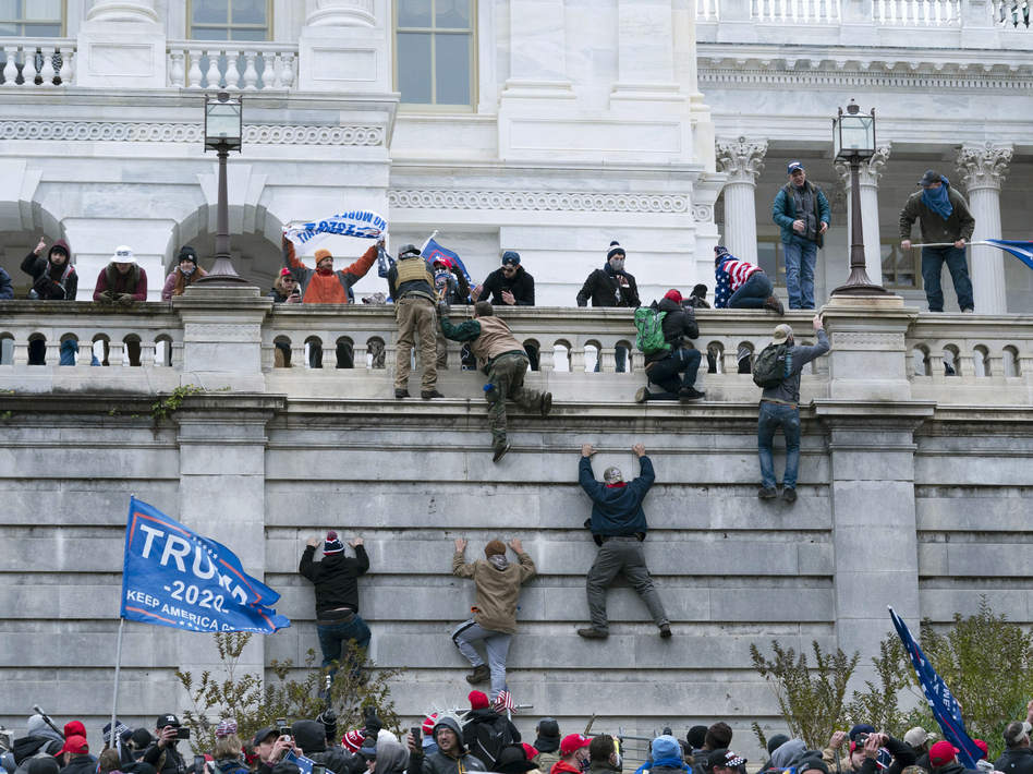 Supporters of then-President Donald Trump climb the west wall of the U.S. Capitol on Jan. 6. (Jose Luis Magana/AP)