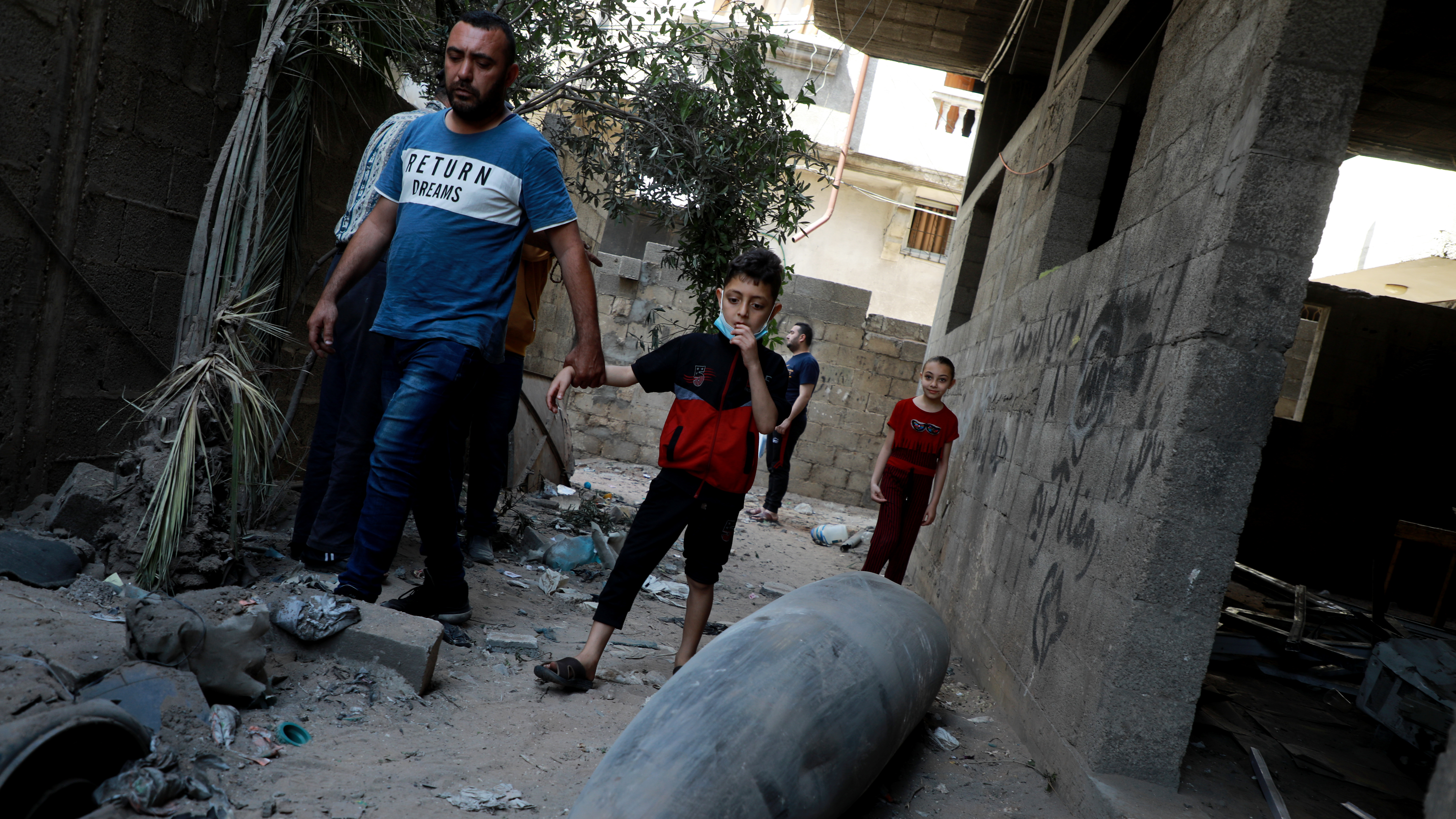 Palestinians look at an unexploded bomb dropped by an Israeli F-16 warplane on Gaza City