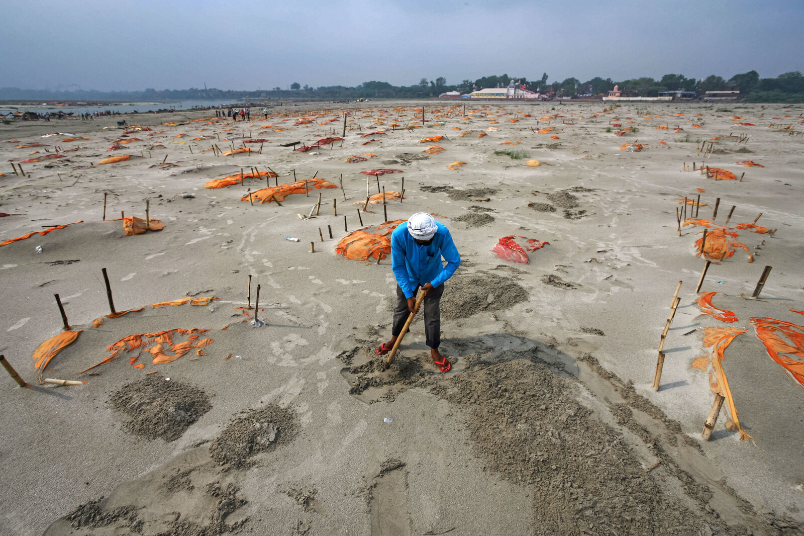 Rains have washed away the top layer of sand of shallow graves at a cremation ground on the banks of the Ganges River in Shringverpur, northwest of Allahabad, Uttar Pradesh, India. Coronavirus testing is limited in parts of rural India, but some of the people buried there are believed to have died of COVID-19.