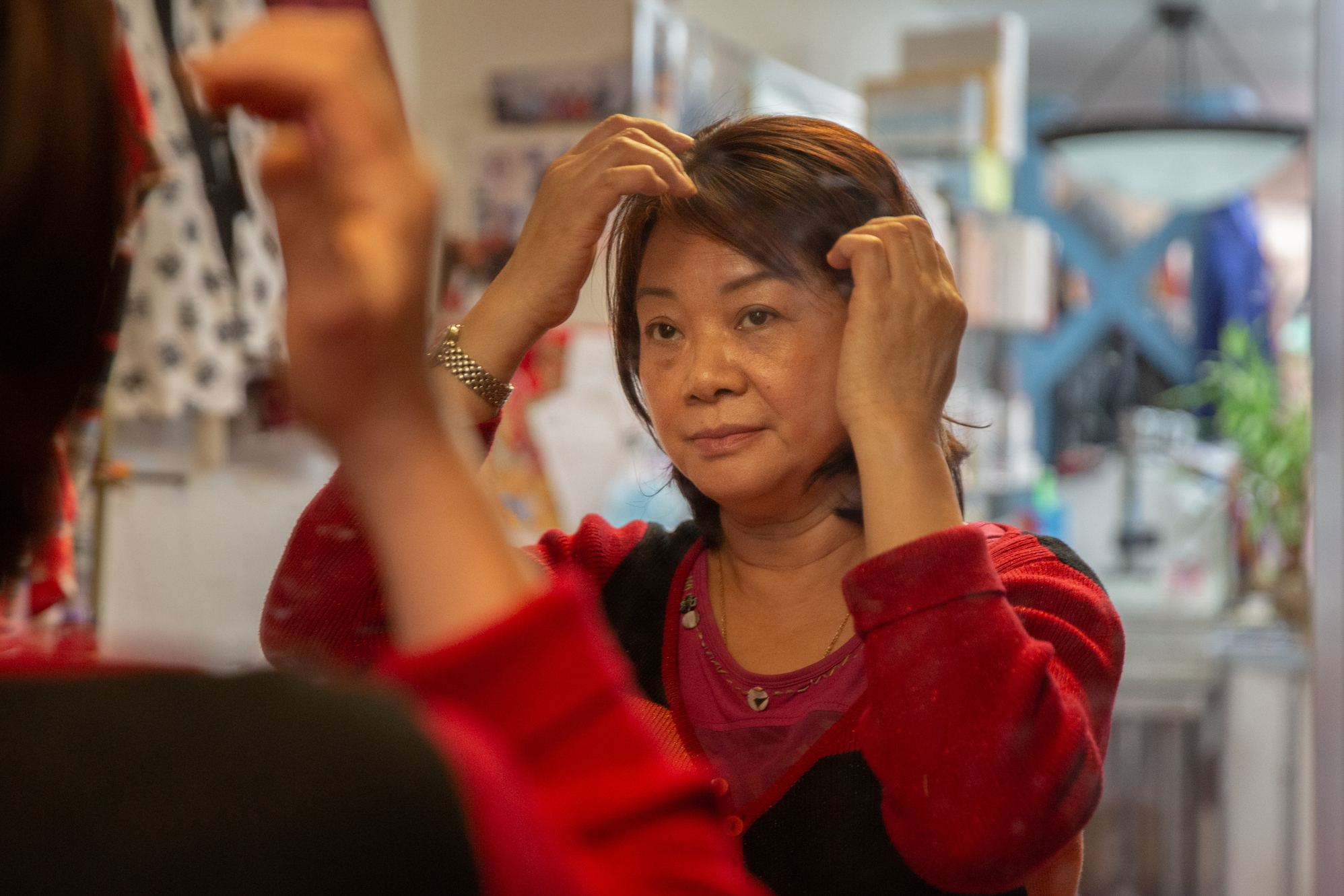 Photos: 2 Cantonese Women Share Their Immigrant Journey 9 Lai adjusts her hair during breaks.