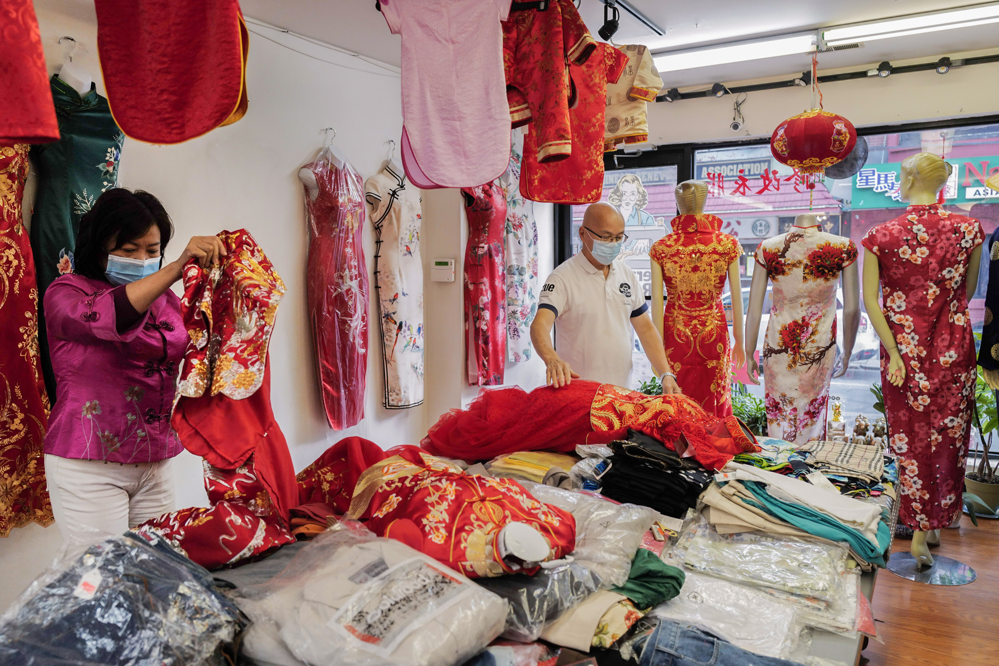 Photos: 2 Cantonese Women Share Their Immigrant Journey 12 In 2000, when Lai saw better housing options in Philadelphia, she decided to move there, founding Dia Boutique, a shop in Chinatown that sells cheongsams and provides alteration services. Here, the couple arrange the cheongsams in the shop.