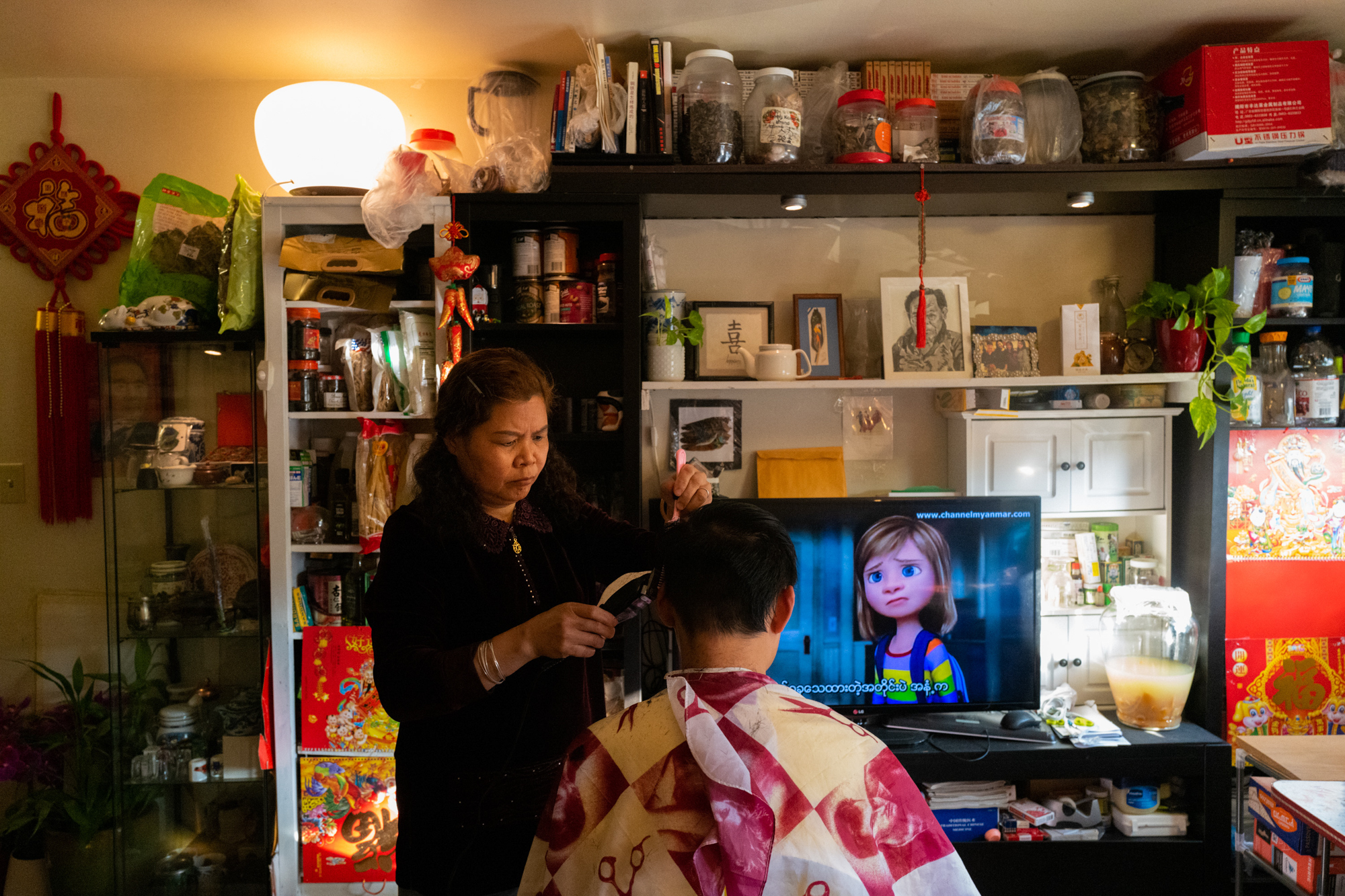 Photos: 2 Cantonese Women Share Their Immigrant Journey 2 Liang gives her son Jackie a haircut.