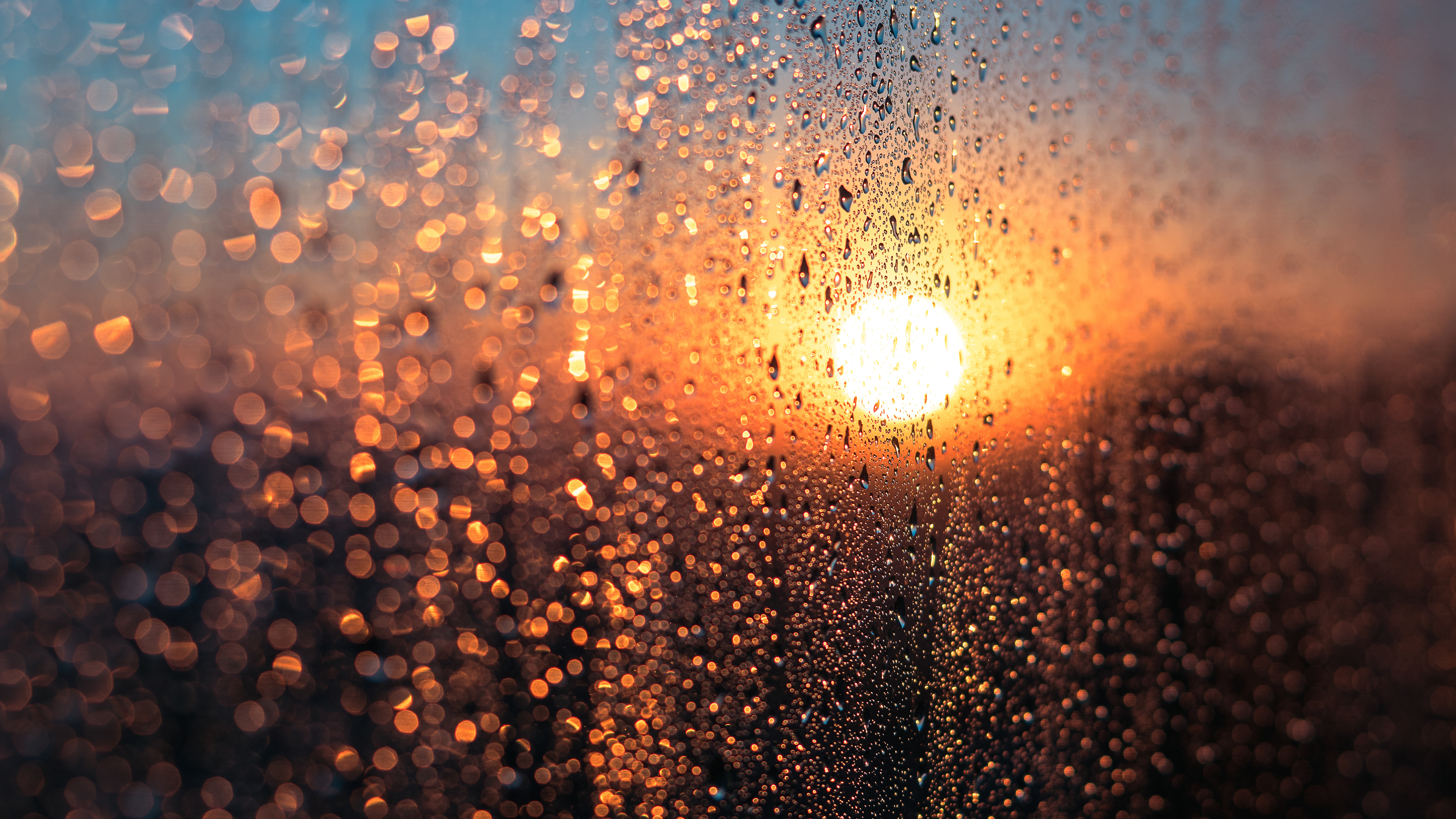 A wet window with condensation set against the sun