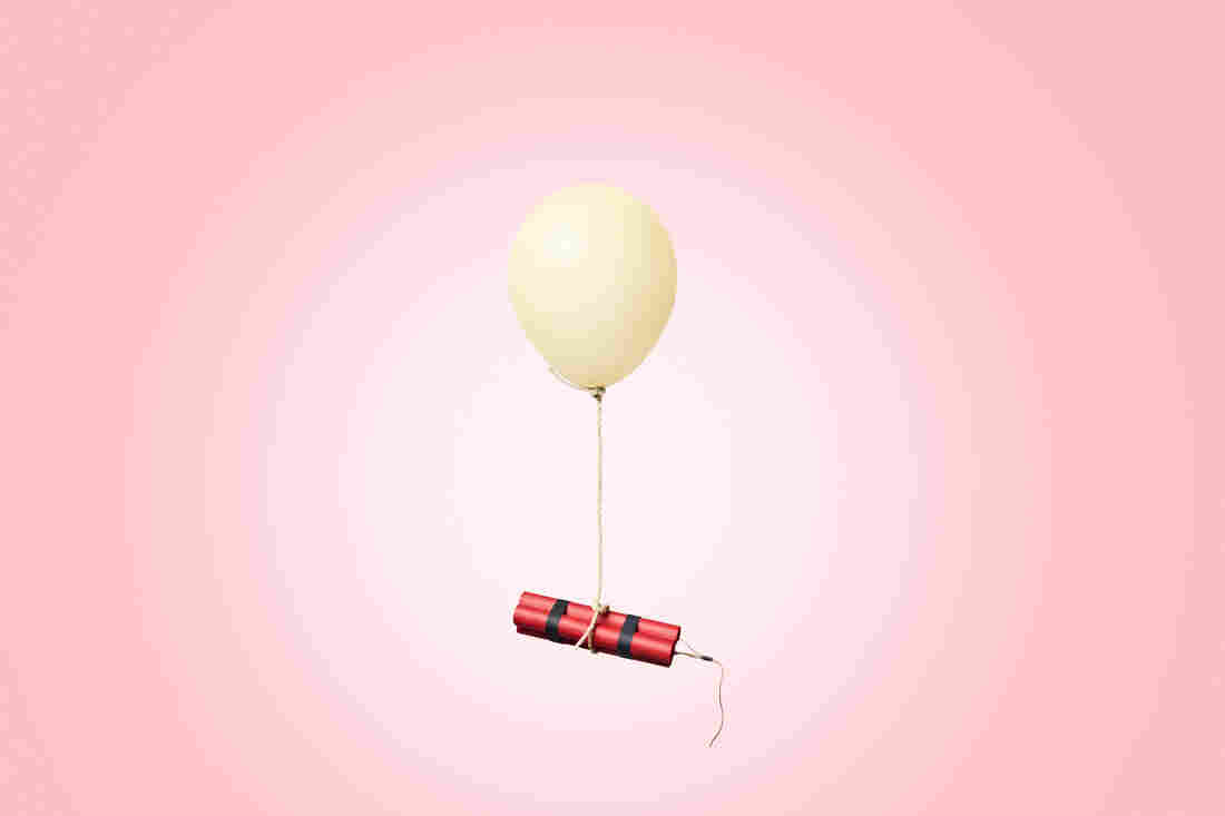 Red dynamite sticks tied up to a balloon with a string and floating in the air