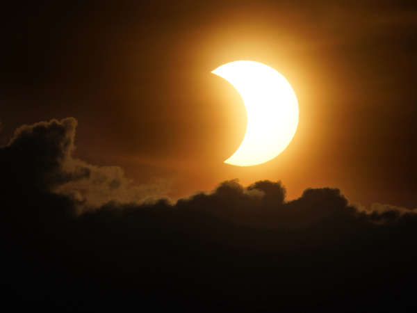 The sun is partially eclipsed as it rises over lower Manhattan in New York on Thursday.