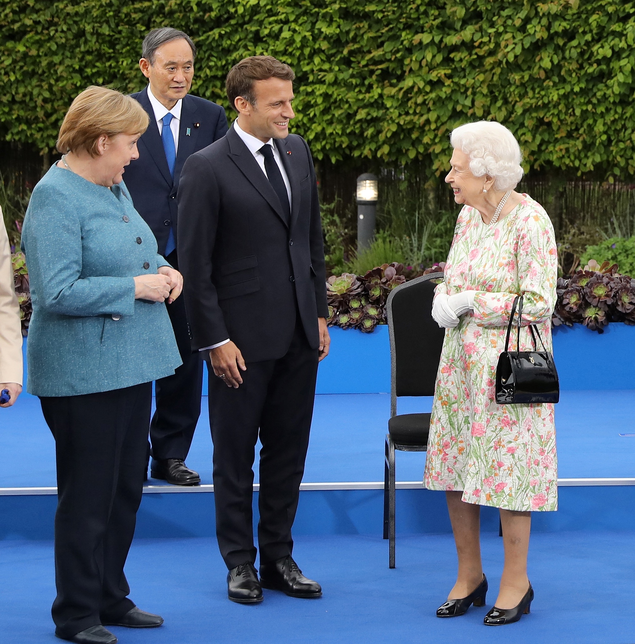 Queen Elizabeth II with Germany's Angela Merkel, Japan's Yoshihide Suga and France's Emmanuel Macron at a reception Friday. The British monarch joined the G-7 leaders for dinner. &quot;Are you supposed to be looking as if you're enjoying this?&quot; she asked as the cameras clicked for a traditional group photo. (Pool/AFP via Getty Images)