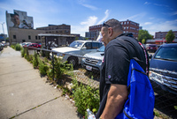 Will wipes away sweat on a hot day while walking down Willow Street in Lynn, Mass., as he looks to distribute safety supplies to drug users on the street.