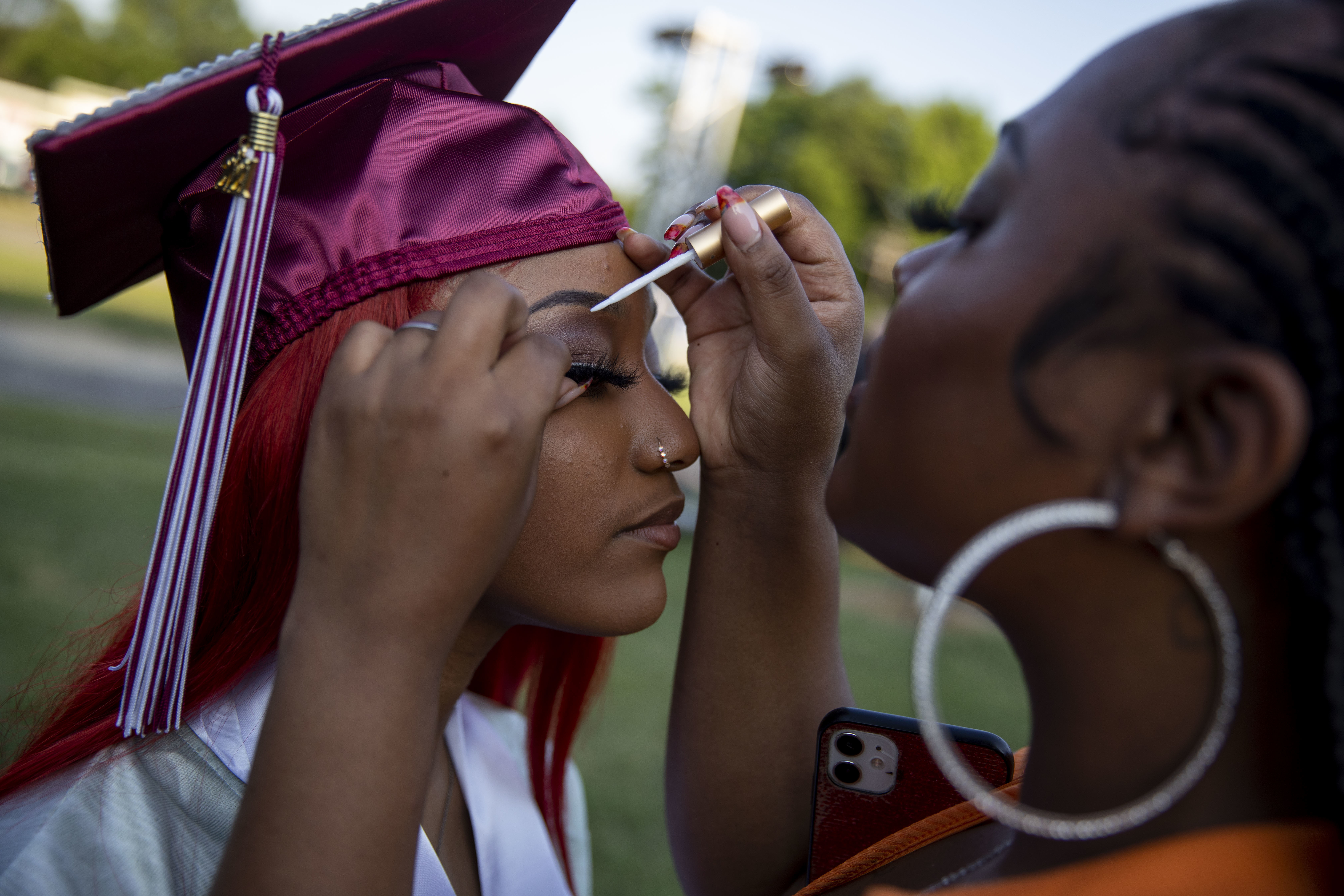 High School Graduations Brought Joy This Year, Even If They Weren't Back To Normal 9 Washington Latin senior Sarah Ce'Taya Hamlett holds still as her cousin, Gina Williams, helps her with her lashes.