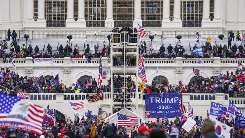 Insurrectionists loyal to former President Donald Trump breach the U.S. Capitol in Washington on Jan. 6. Prosecutors have secured the first guilty plea in a conspiracy case brought against members of the Oath Keepers extremist group in the attack. (John Minchillo/AP)