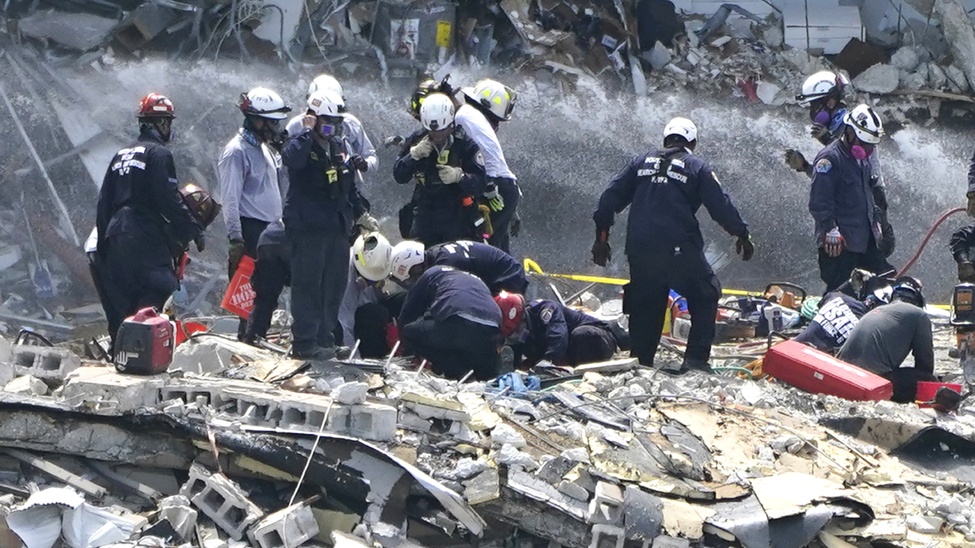                  Rescue workers search the rubble of the Champlain Towers South condominium on Saturday in the Surfside area of Miami. The building pa