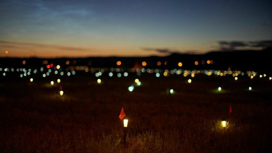 Solar lights and flags now mark the spots where 751 human remains were recently discovered in unmarked graves at the site of the former Marieval Indian Residential School on the Cowessess First Nation in Saskatchewan. (AFP via Getty Images)