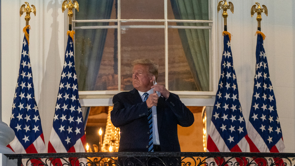 According to one new account of the Trump presidency, even telling the story of President Trump's Covid diagnosis was difficult due to the chaos in the white house. Here, Trump removes his protective mask after being discharged from the Walter Reed National Military Medical Center with Covid-19.