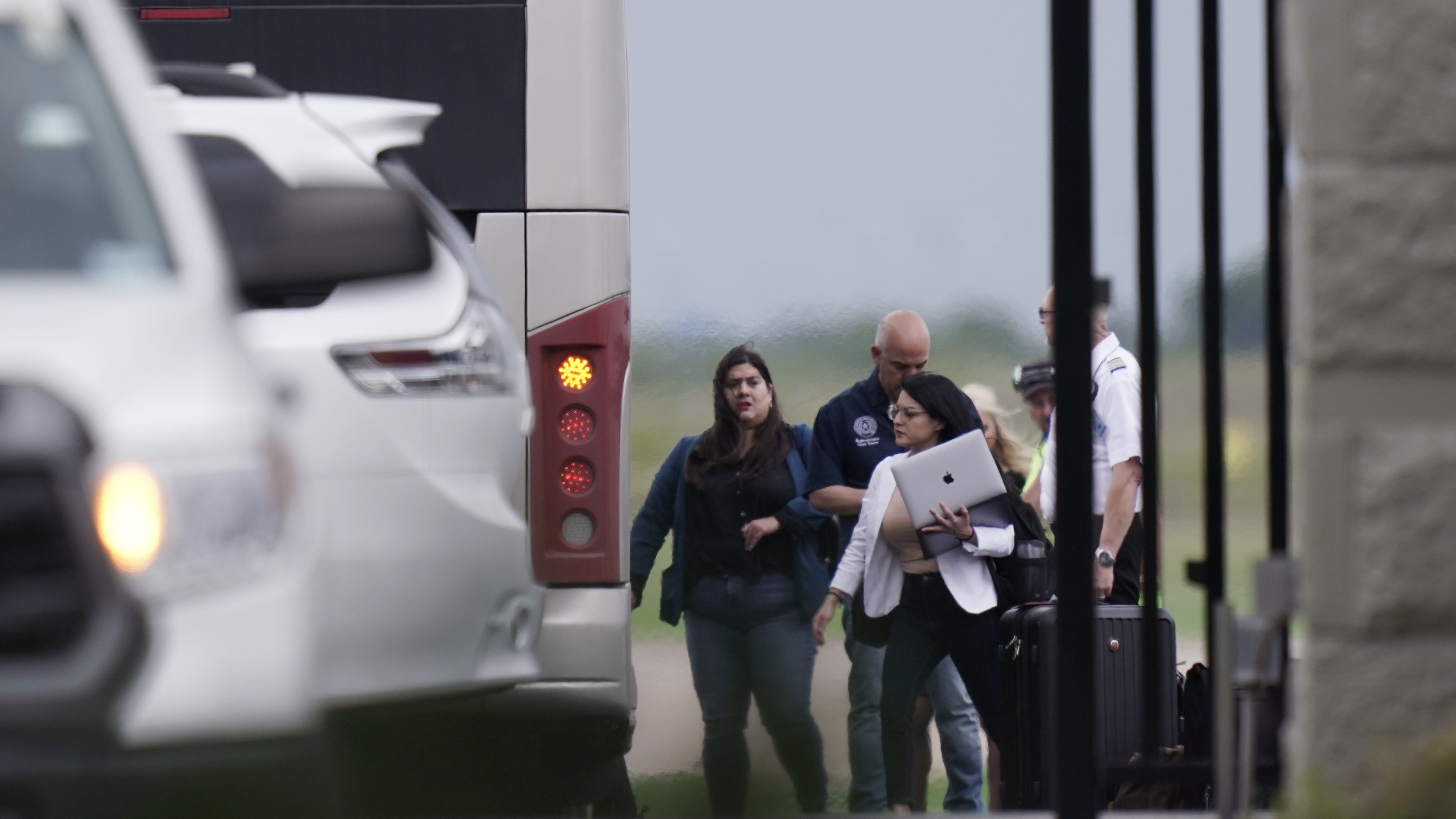Democrats from the Texas Legislature arrive by bus to board a private plane in Austin to travel to Washington, D.C., on Monday. The lawmakers fled the state to try to block action on GOP election bills.