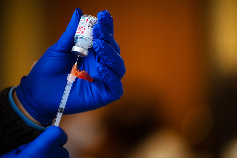 A medical technician fills a syringe from a vial of the Moderna COVID-19 vaccine earlier this year. (Jon Cherry/Getty Images)