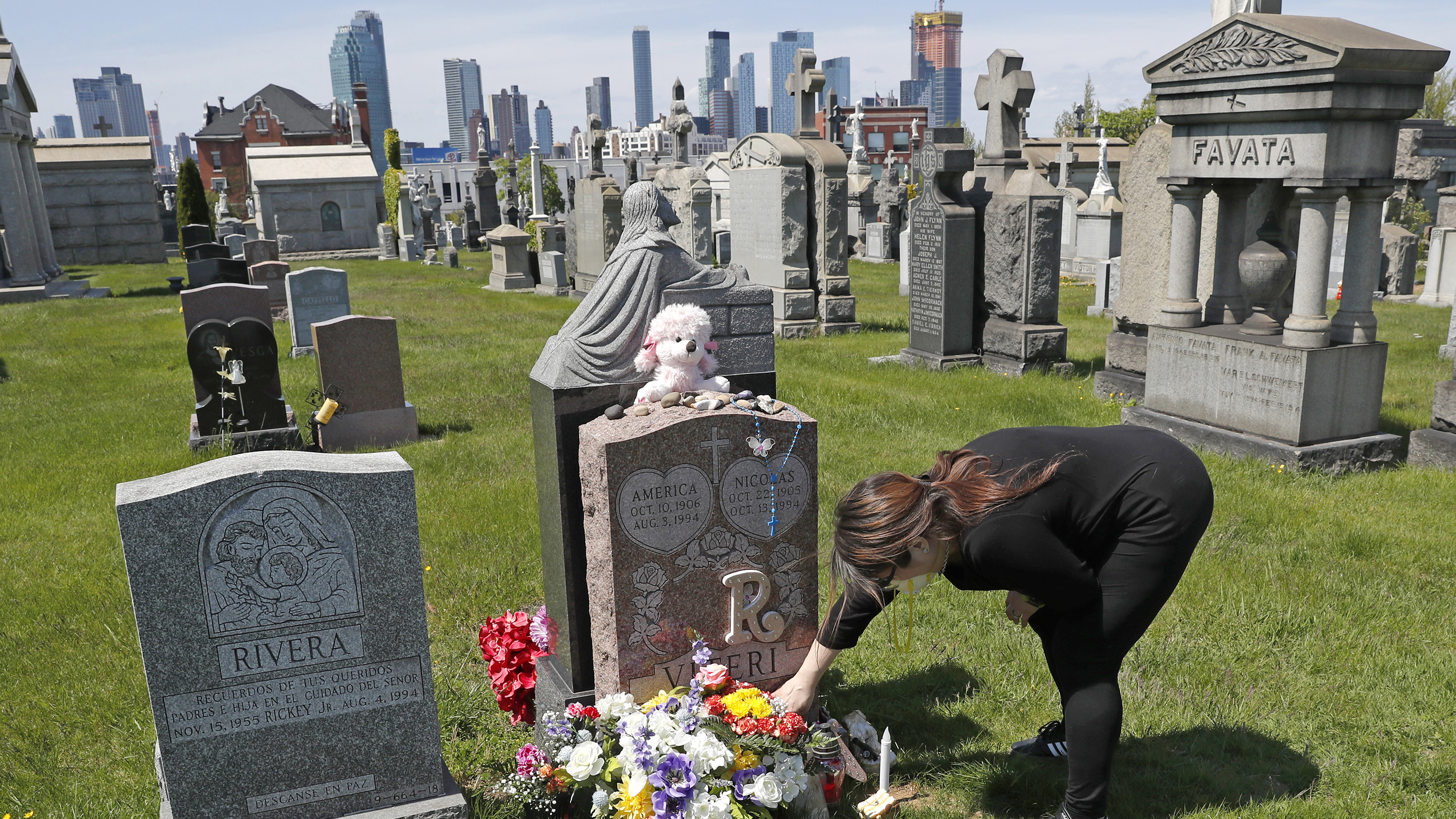 Sharon Rivera adjusts flowers at the grave of her daughter, Victoria, at Calvary Cemetery in New York last Mother