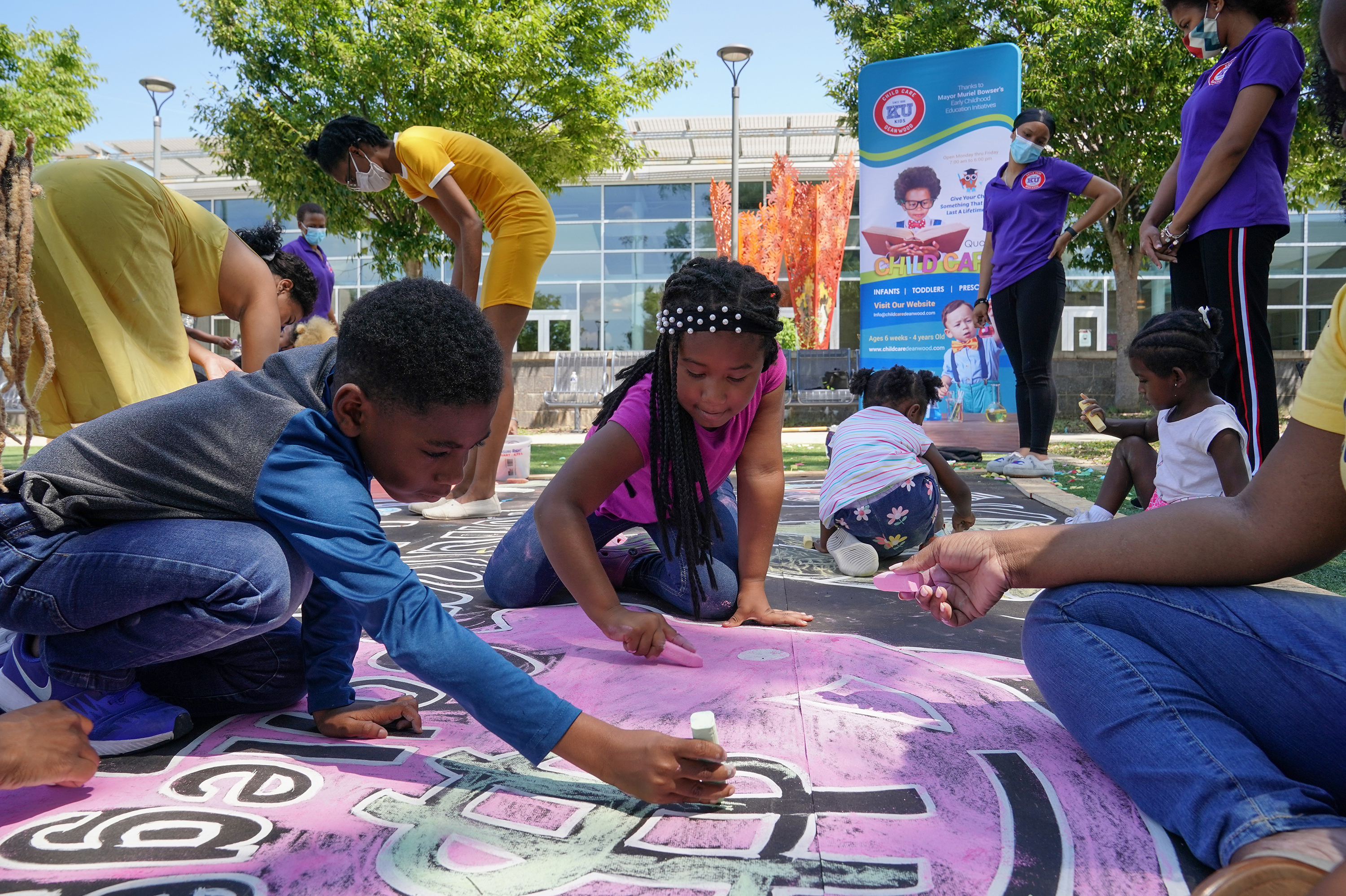 Children and teachers from the KU Kids Deanwood child care center in Washington, D.C., complete a mural in celebration of the launch of the child tax credit. (Getty Images for Community Change)