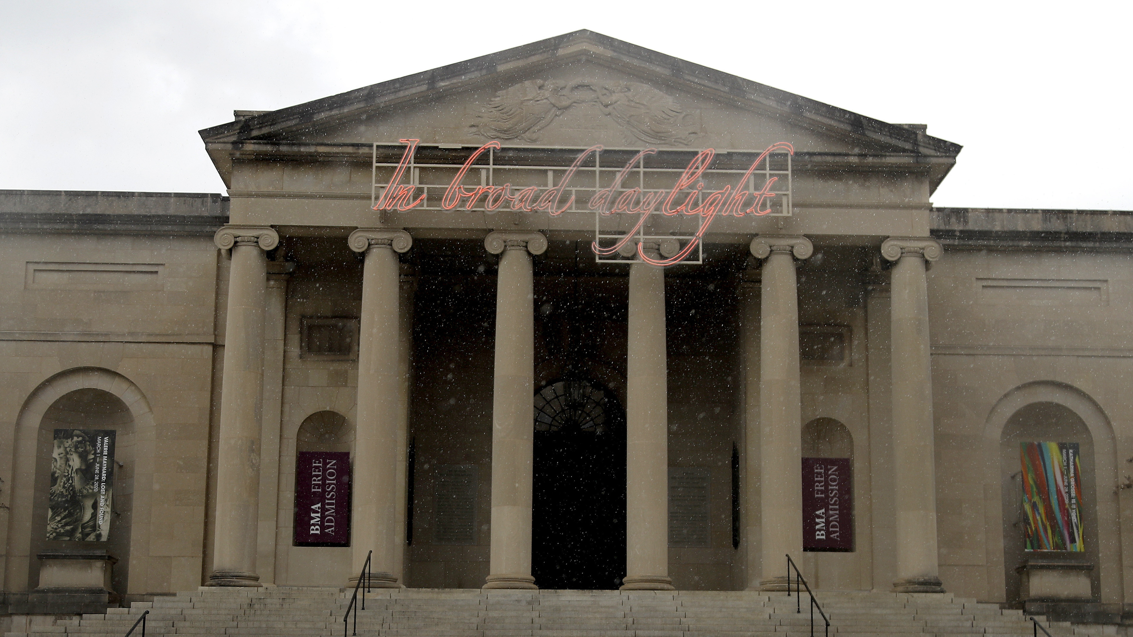 A man covers himself from rain with an umbrella as he walks by the Baltimore Museum of Art on April 21, 2020. An upcoming exhibit at the museum will be curated by security guards.