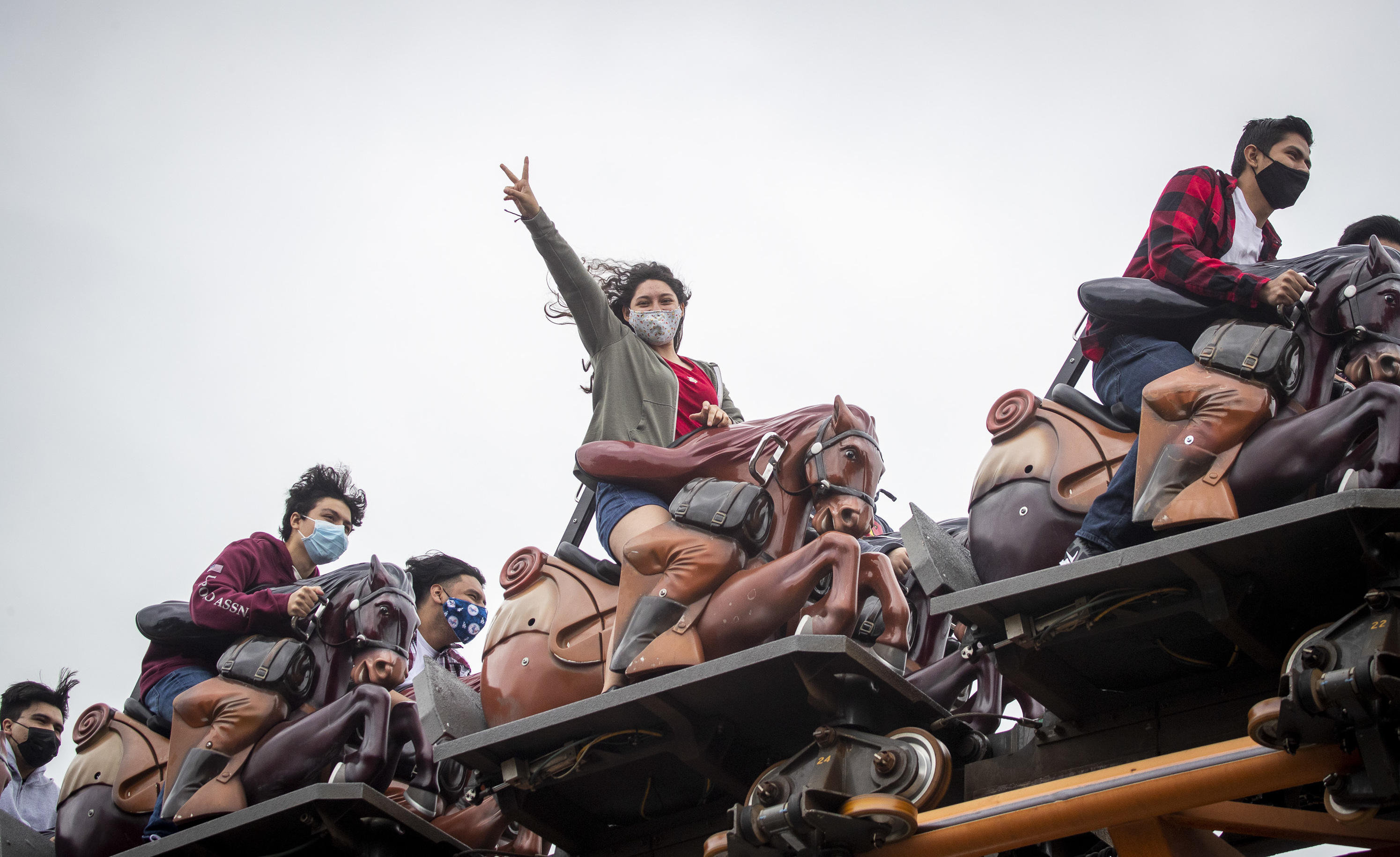 To mask or not to mask: That is the question for vaccinated people as the delta variant surges. The answer may depend on the situation, experts say. Here, these roller coaster riders mask up at Knott's Berry Farm in Buena Park, Calif. (Los Angeles Times via Getty Images)