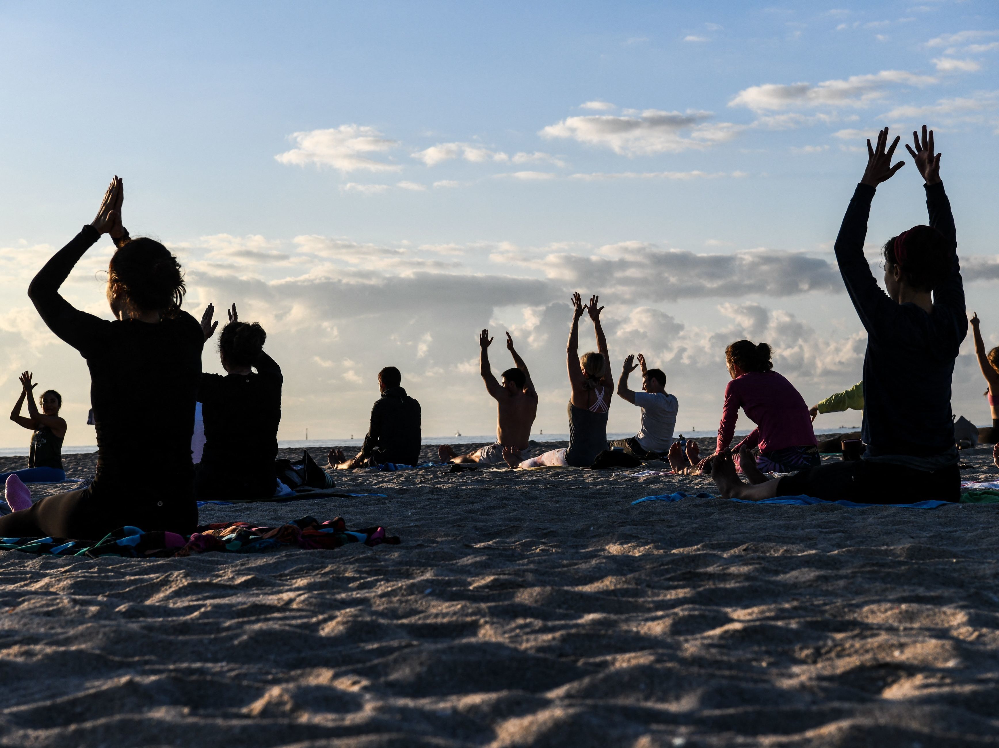 People do yoga on the beach in Miami Beach, Fla., on March 23. (AFP via Getty Images)