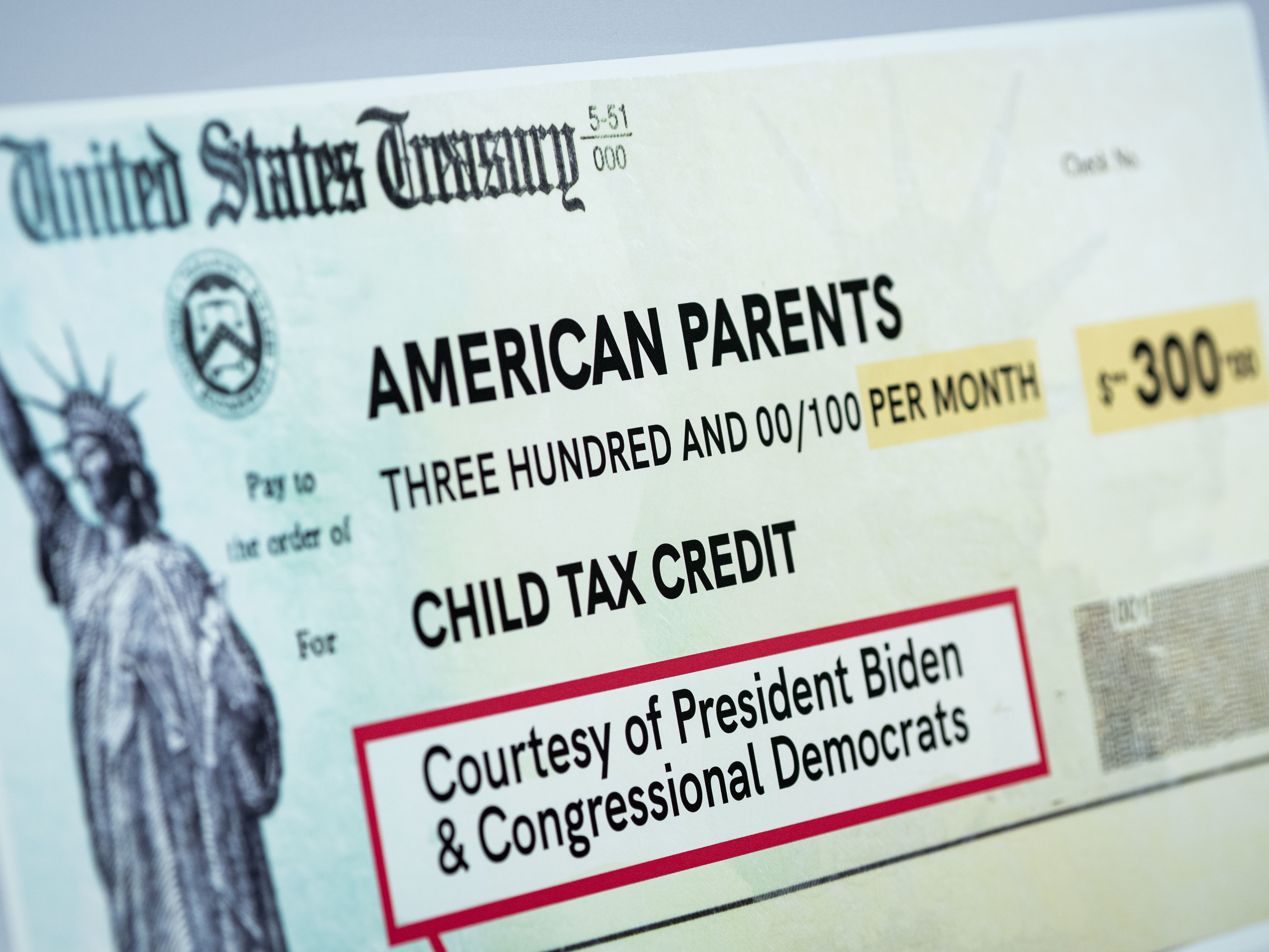 A child tax credit poster is displayed during a news conference in Washington, D.C., on July 15. Early data shows that after the child tax credit payments went out this summer, the number of households with children who experience food insufficiency dropped. (Bloomberg via Getty Images)