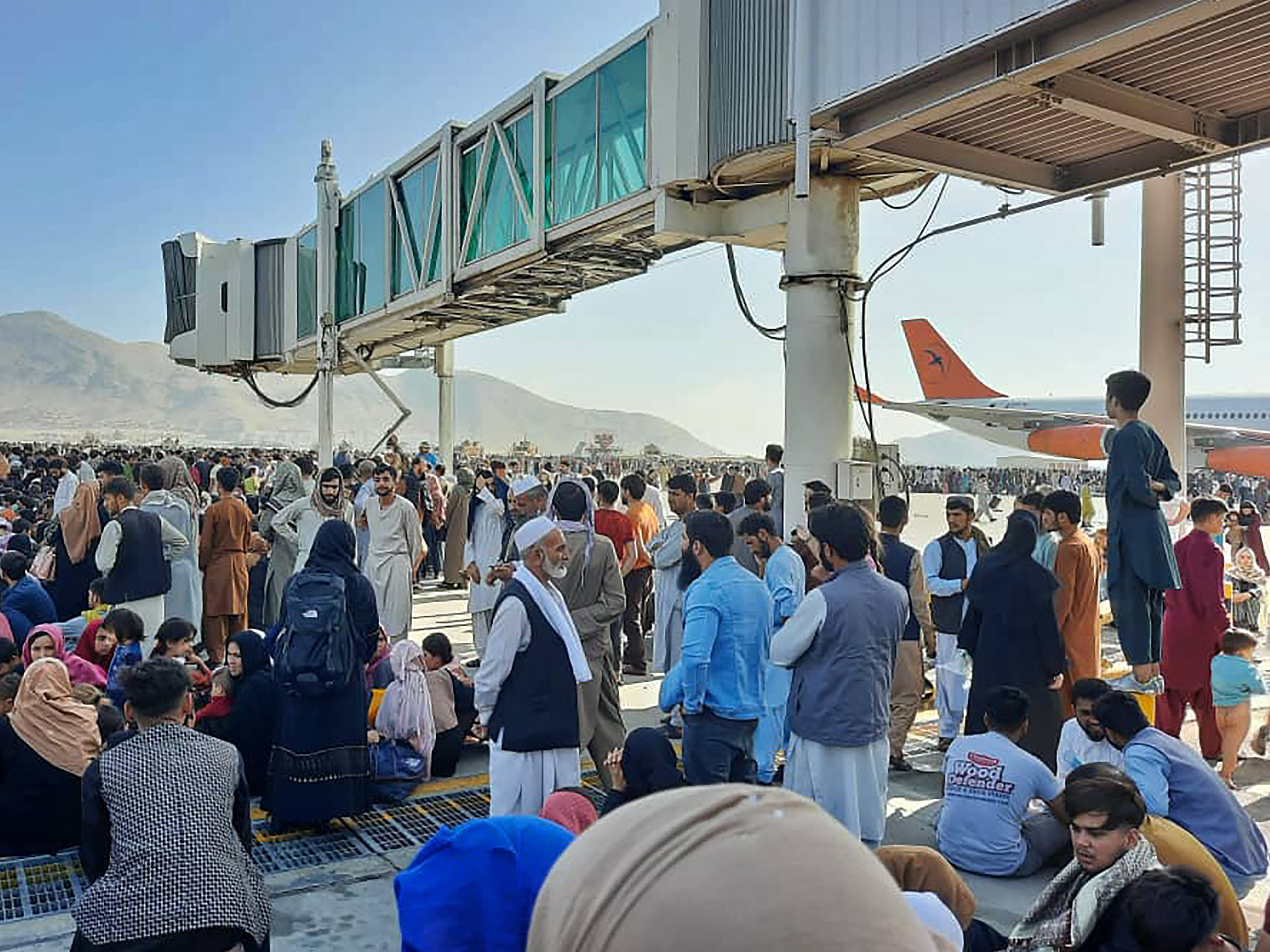 Afghans crowd the tarmac of the Kabul airport on Monday to flee the country. Thousands of people mobbed the city's airport trying to flee the group's feared hardline brand of Islamist rule. (AFP via Getty Images)
