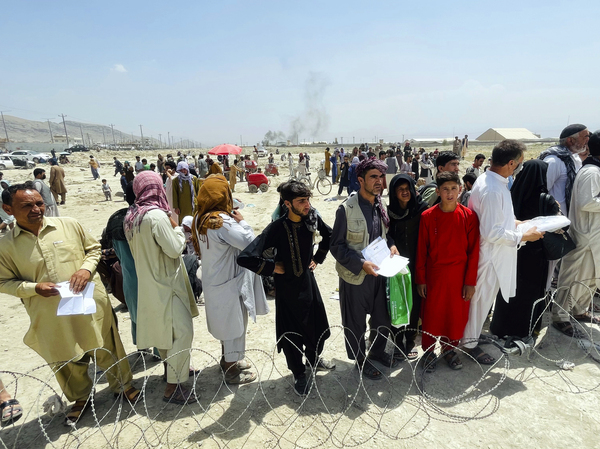 Hundreds of people gather outside the international airport in Kabul, Afghanistan, on Tuesday.