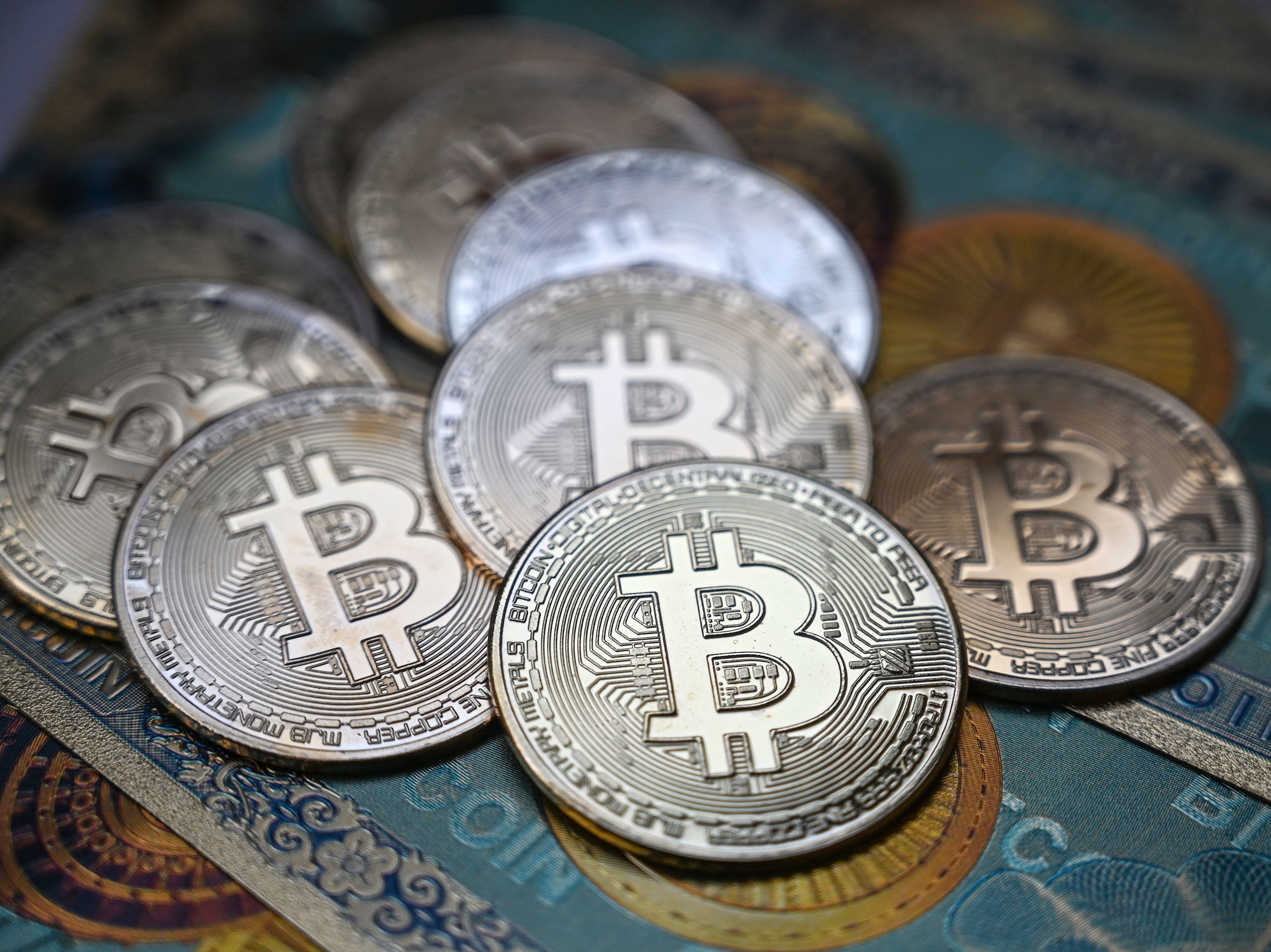 This illustration photograph taken on July 19 in Istanbul shows a physical banknote and coin imitations of the Bitcoin cryptocurrency. Regulators such as Securities and Exchange Commission Chairman Gary Gensler are promising tougher action for cryptocurrencies. (AFP via Getty Images)