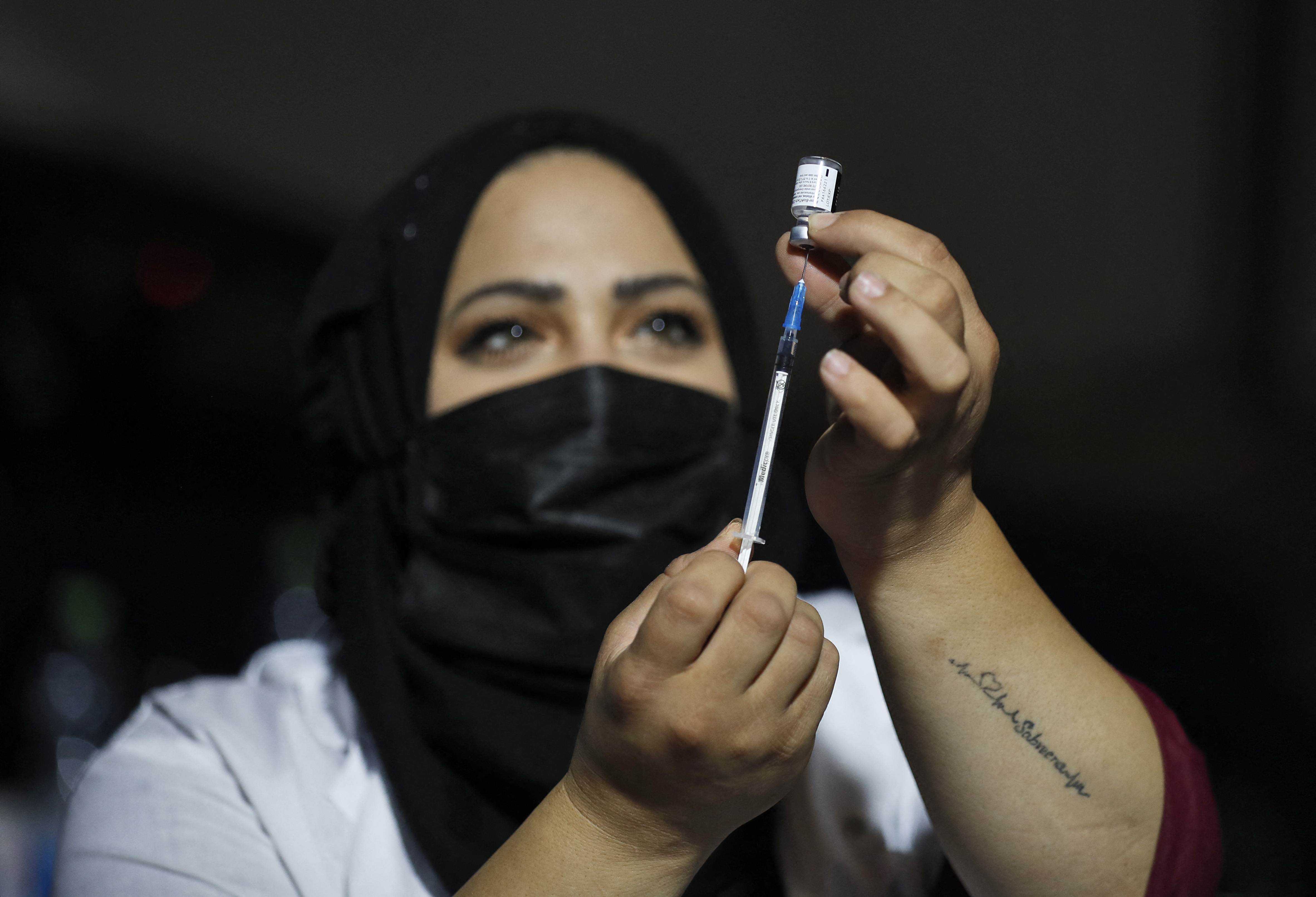 An Israeli health worker prepares to administer a third dose of the Pfizer-BioNtech Covid-19 vaccine to Jewish ultra-Orthodox people at a religious neighborhood in Jerusalem on August 19, 2021. (AFP via Getty Images)