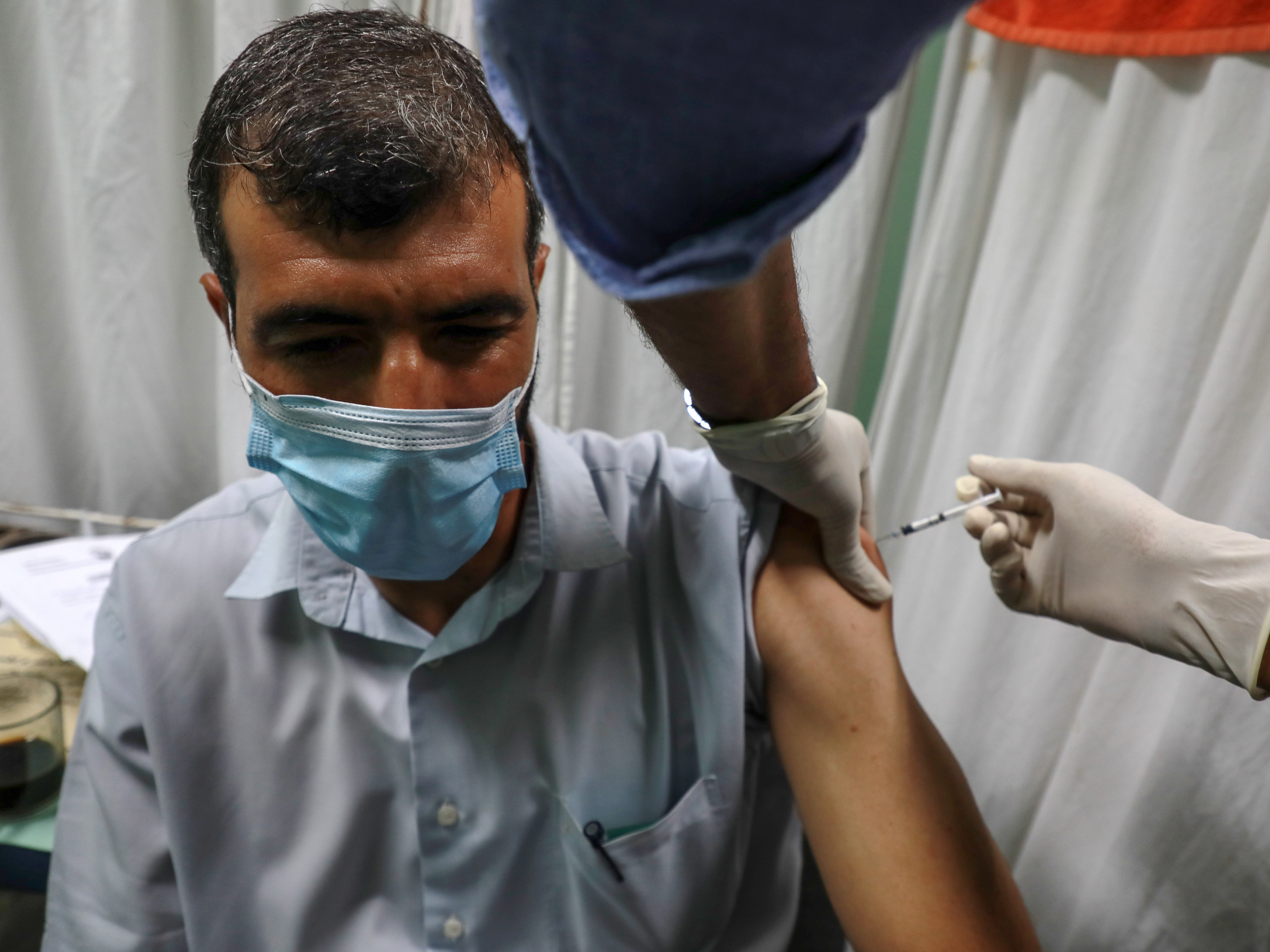 A Palestinian medic administers a dose of the Pfizer-BioNTech COVID vaccine during an inoculation campaign at a medical center in Gaza City on Aug. 23. (NurPhoto via Getty Images)
