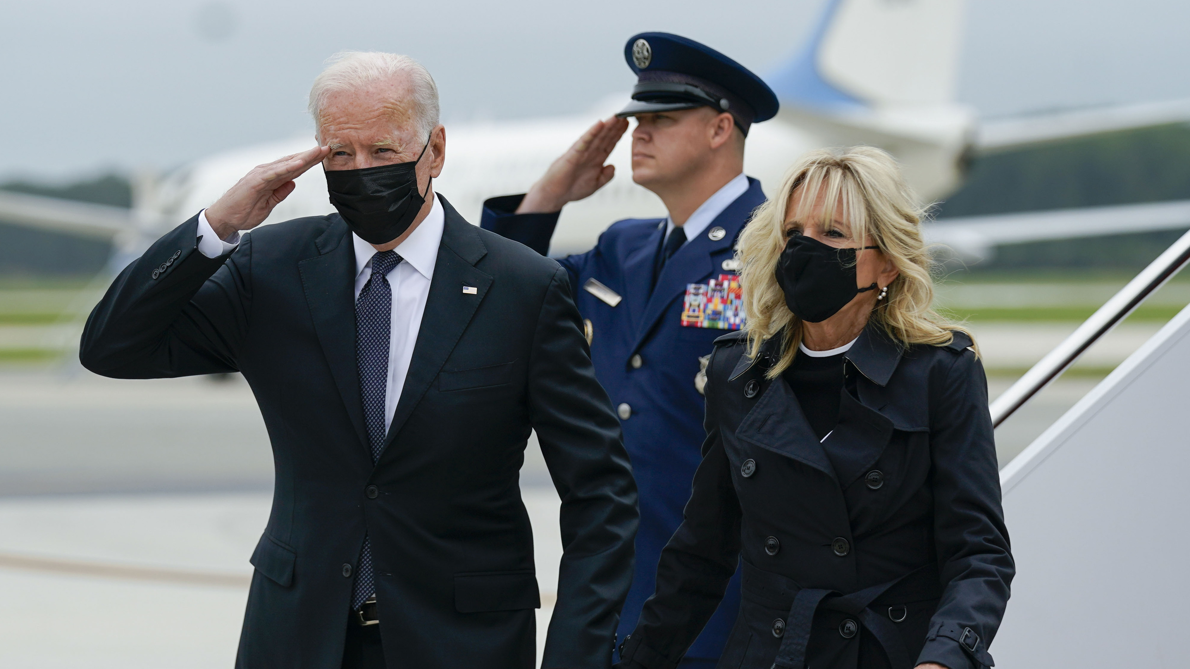 President Biden returns a salute as he and first lady Jill Biden arrive at Dover Air Force Base, Del., Sunday, Aug. 29, 2021. Biden embarked on a solemn journey Sunday to honor and mourn the 13 U.S. troops killed in the suicide attack near the Kabul airport as their remains return to U.S.