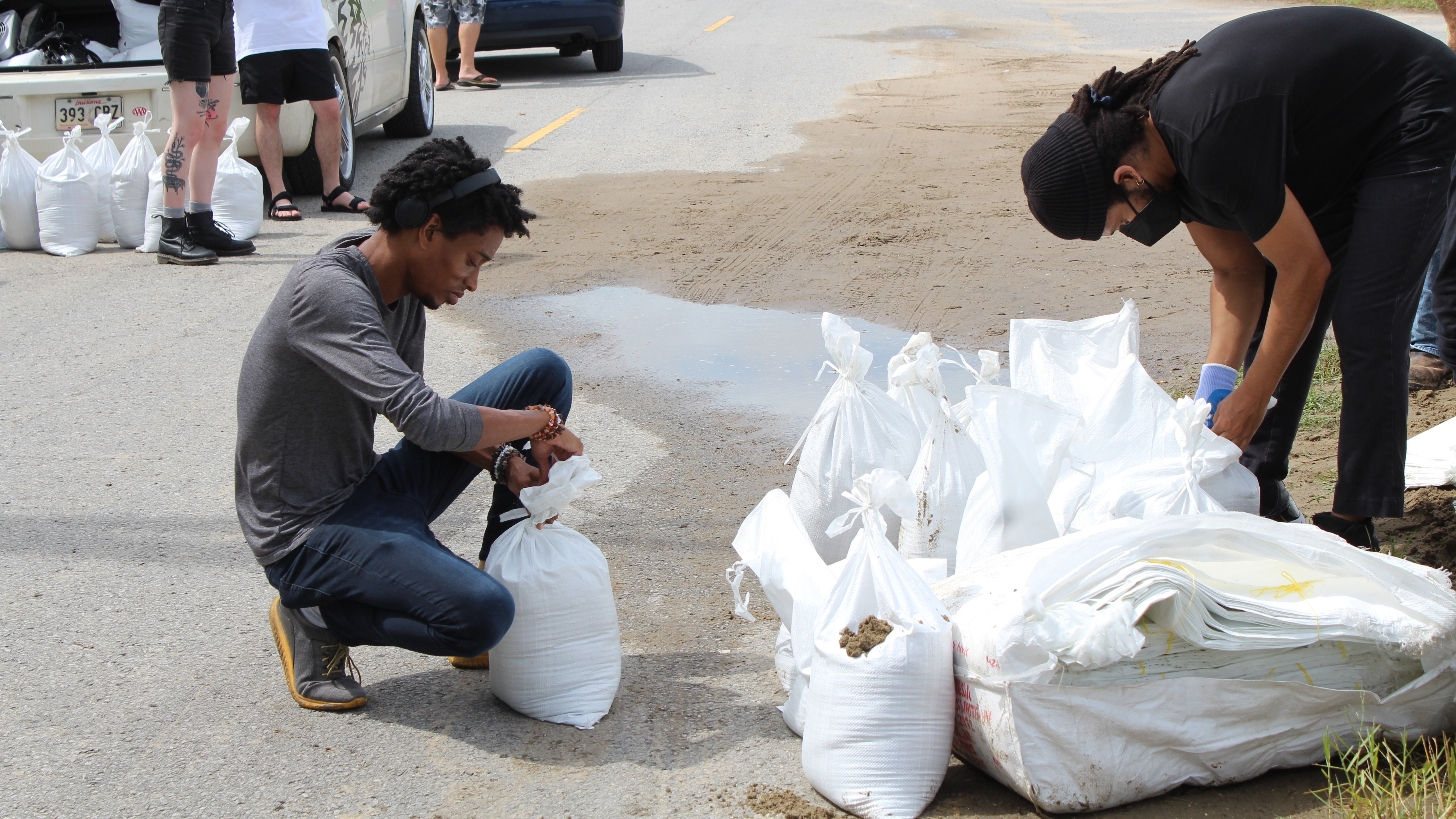 New Orleans residents Jordan Bridges and David Jones pack sandbags as they prepare to ride out the storm. Bridges described Katrina as a &quot;stain&quot; on the city's soul. (WWNO)