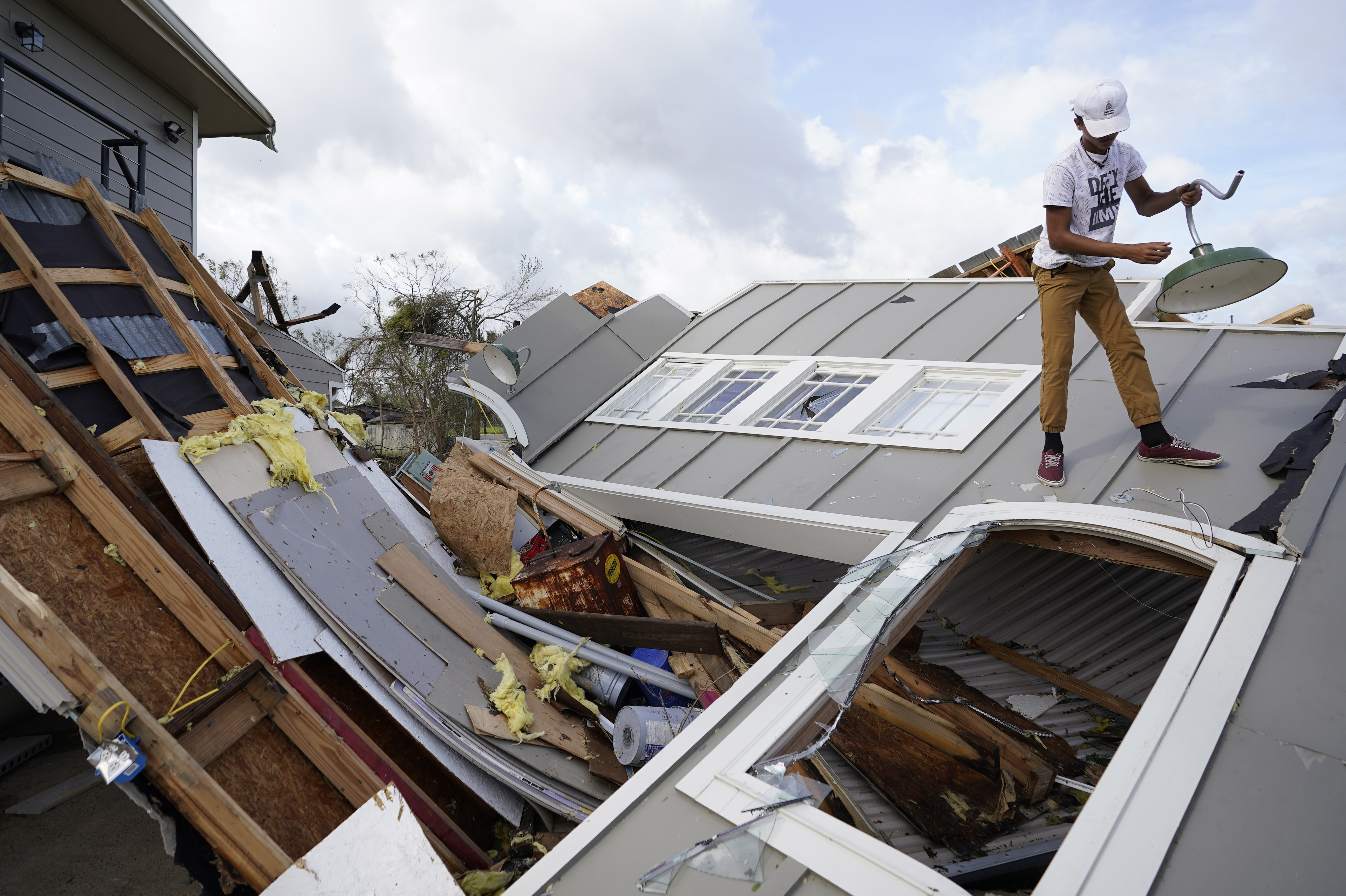 Mon., Aug. 30: Jeremy Hodges removes a light from his family's destroyed storage unit in Houma, La.