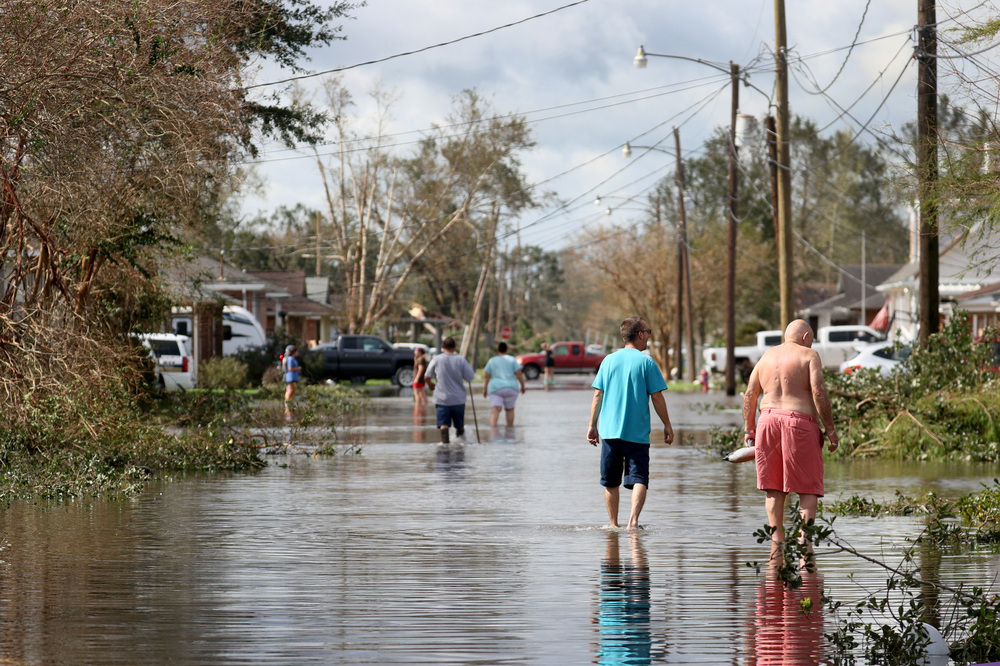 Residents walk down a flooded residential street in the aftermath of Hurricane Ida on Monday in Norco, La. Ida made landfall on Sunday as a Category 4 storm southwest of New Orleans. (Getty Images)