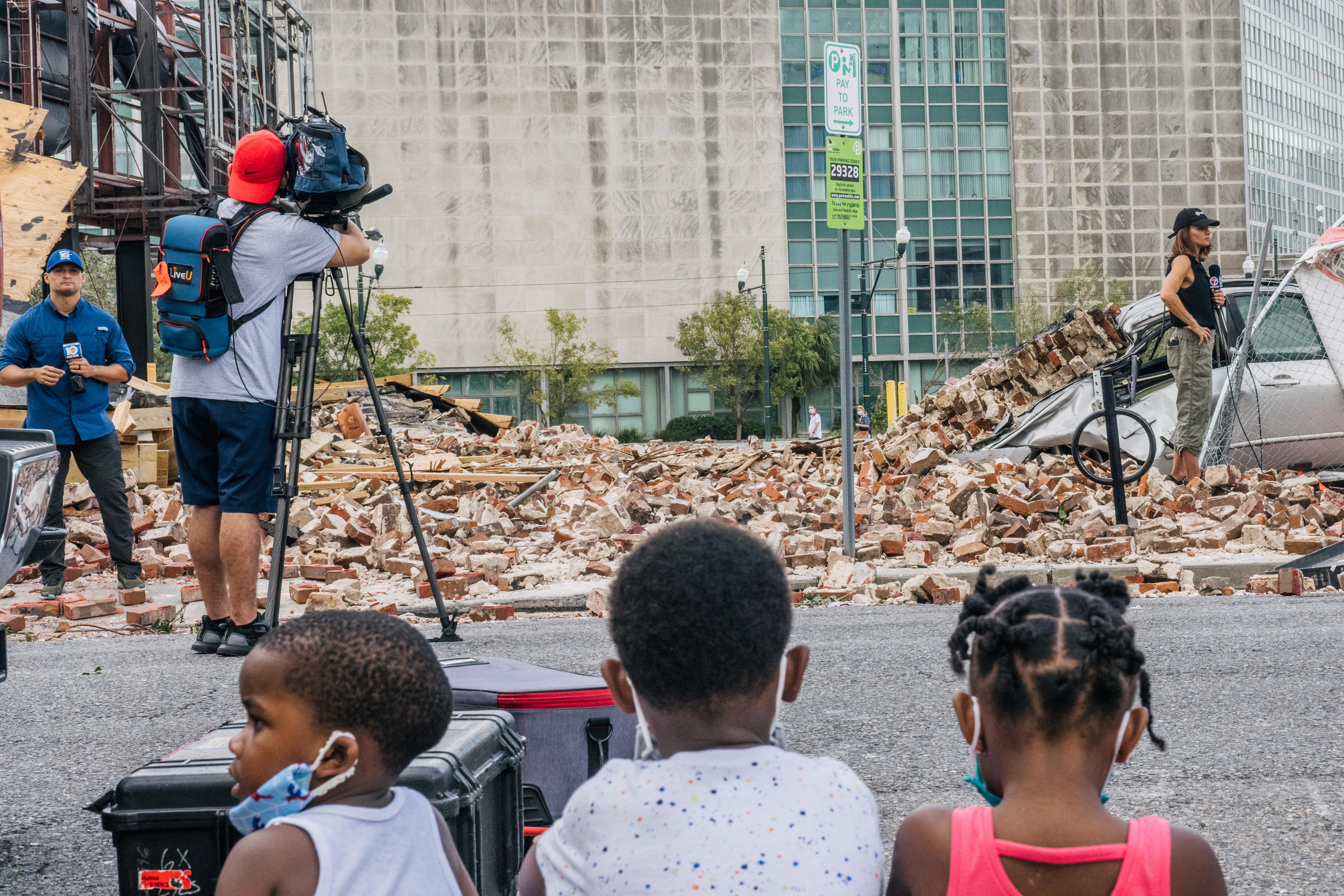 Mon., Aug. 30: Children watch reporters at a building collapse scene in New Orleans.