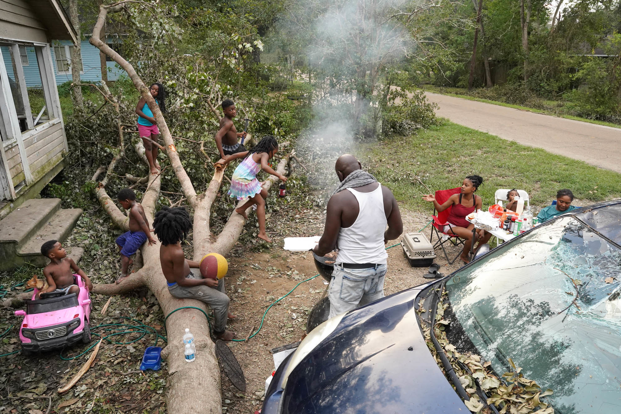 Wednesday., Sept. 1: A family without power prepares for dinner in their front yard after Hurricane Ida in Hammond, La.