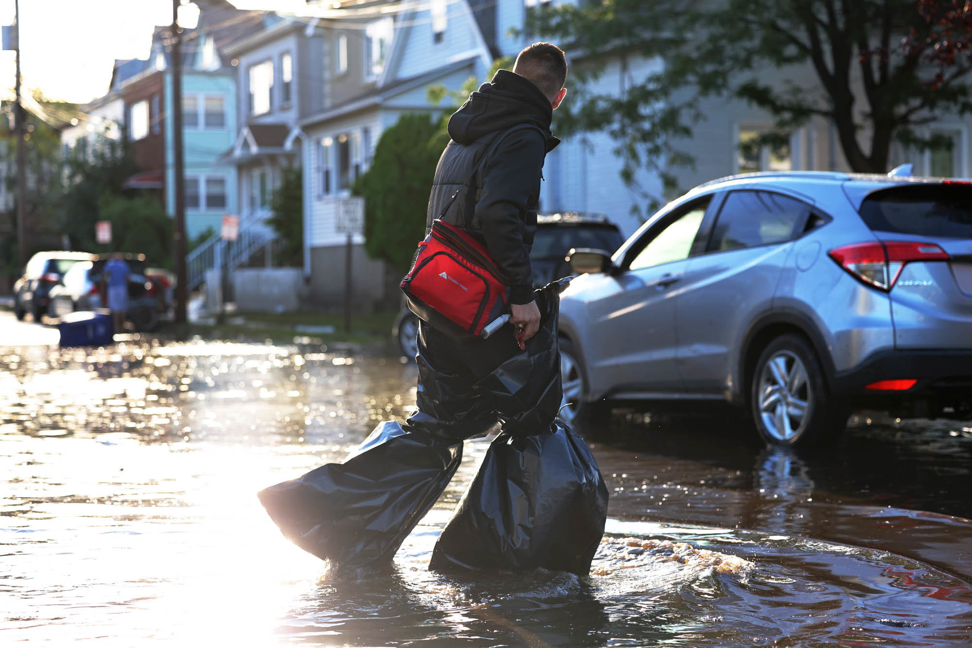 Thursday., Sept. 2: A man uses garbage bags to keep his pants and feet dry as he crosses a flooded Lester Street in Passaic City.