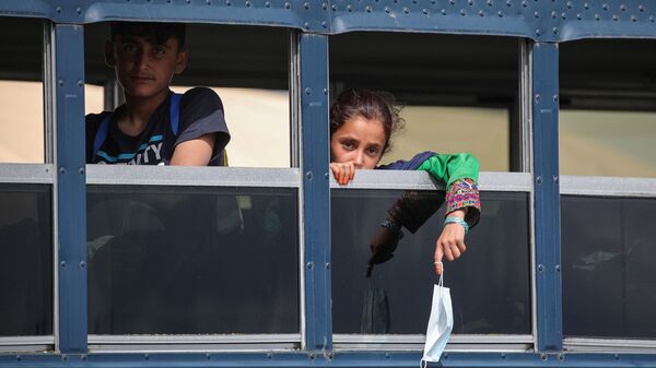 Afghan evacuees sit on a bus at the U.S. air base in Ramstein, Germany, on Aug. 26. Ramstein Air Base, the largest U.S. Air Force base in Europe, has hosted thousands of Afghans.